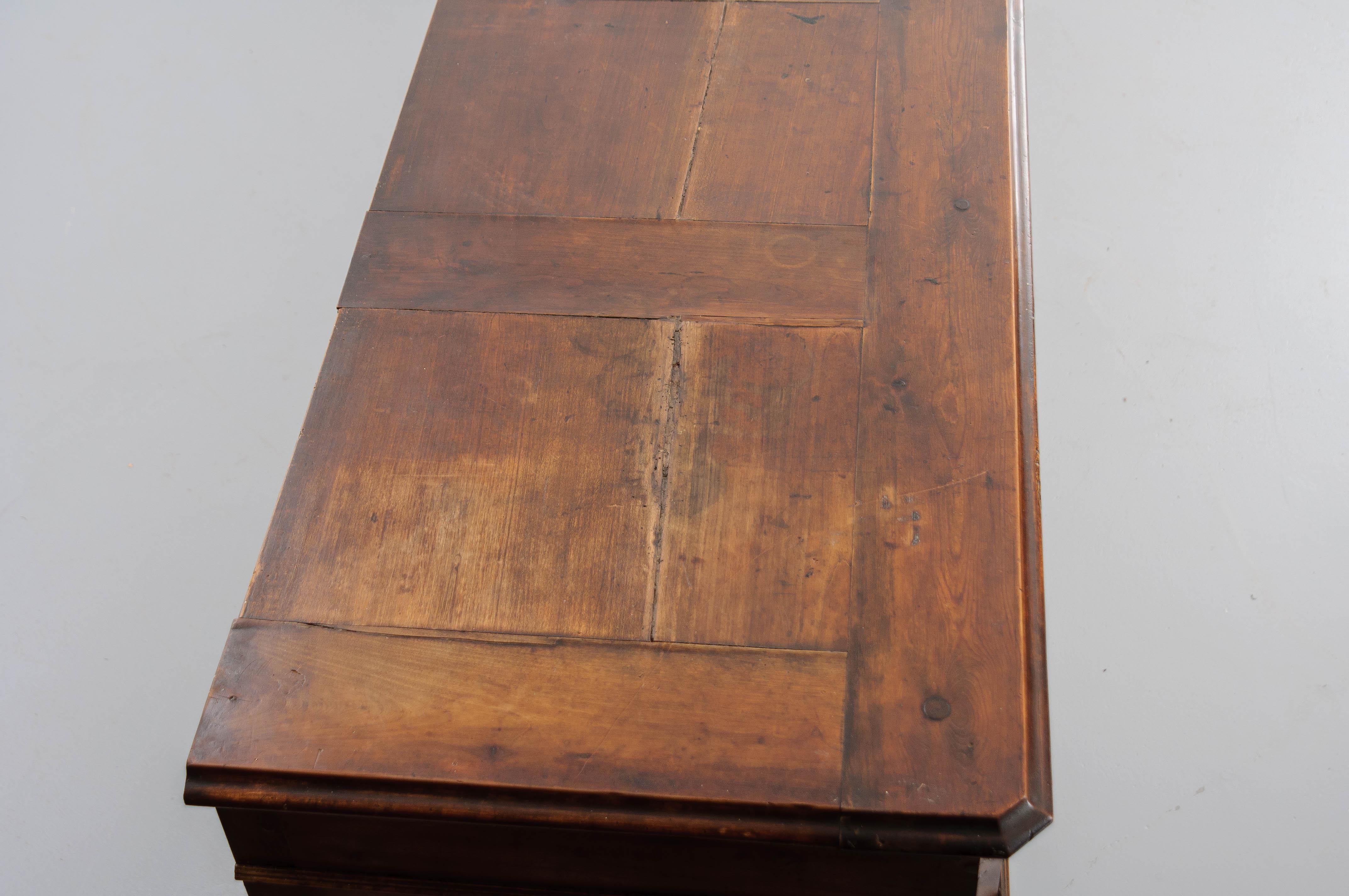 This 19th century French walnut enfilade is quite substantial in size. The apron has eight drawers each with a turned wood drop pull. The body of the Enfilade has four sets of recessed panel doors with a fixed shelf behind each set of doors. The