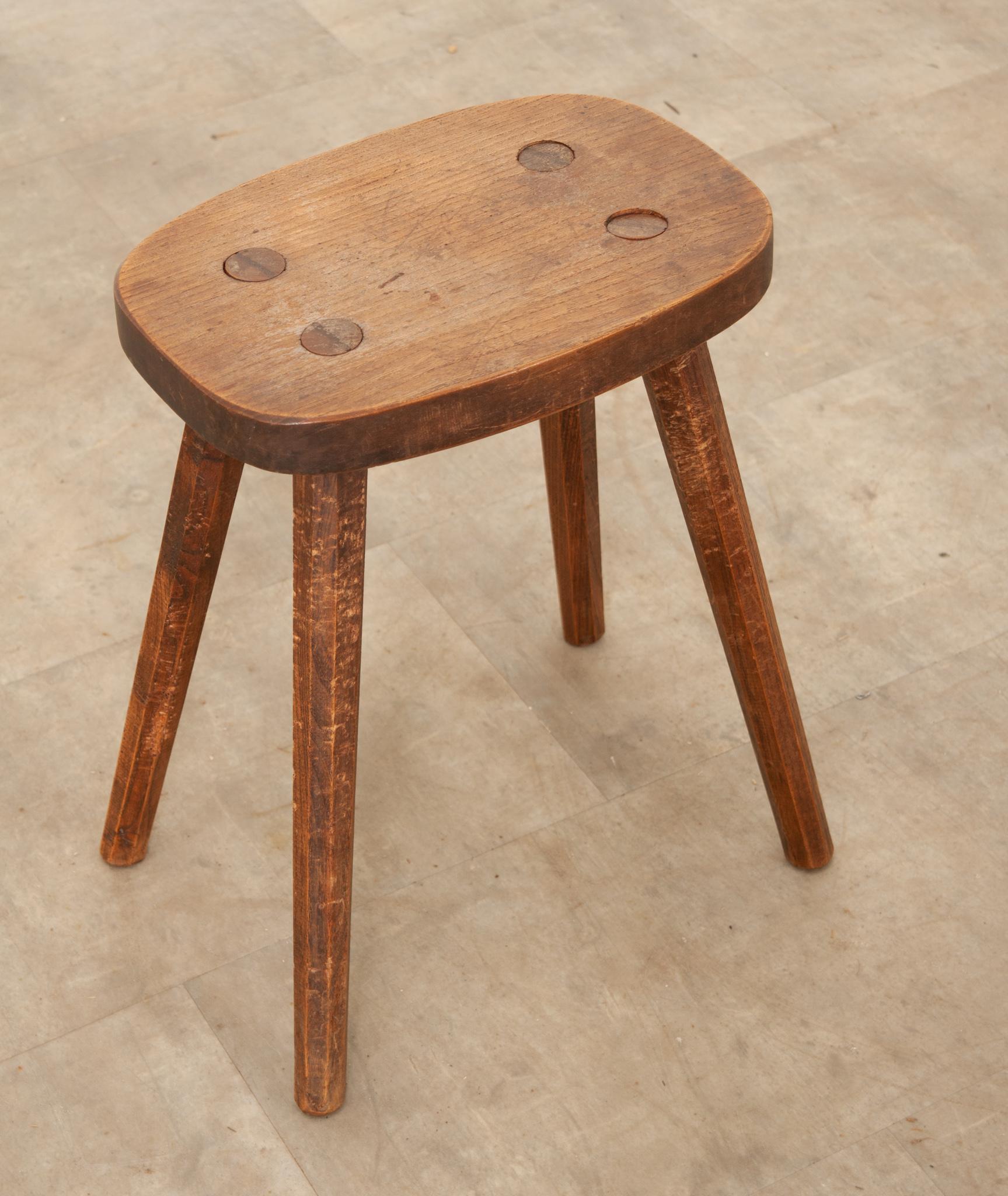 Contact from countless hours spent on the farm have patinated the top of this wonderful French milking stool. Its rectangular top is supported by four splayed legs in a simple construction. Dating to the 1800s, this wonderful antique seat could