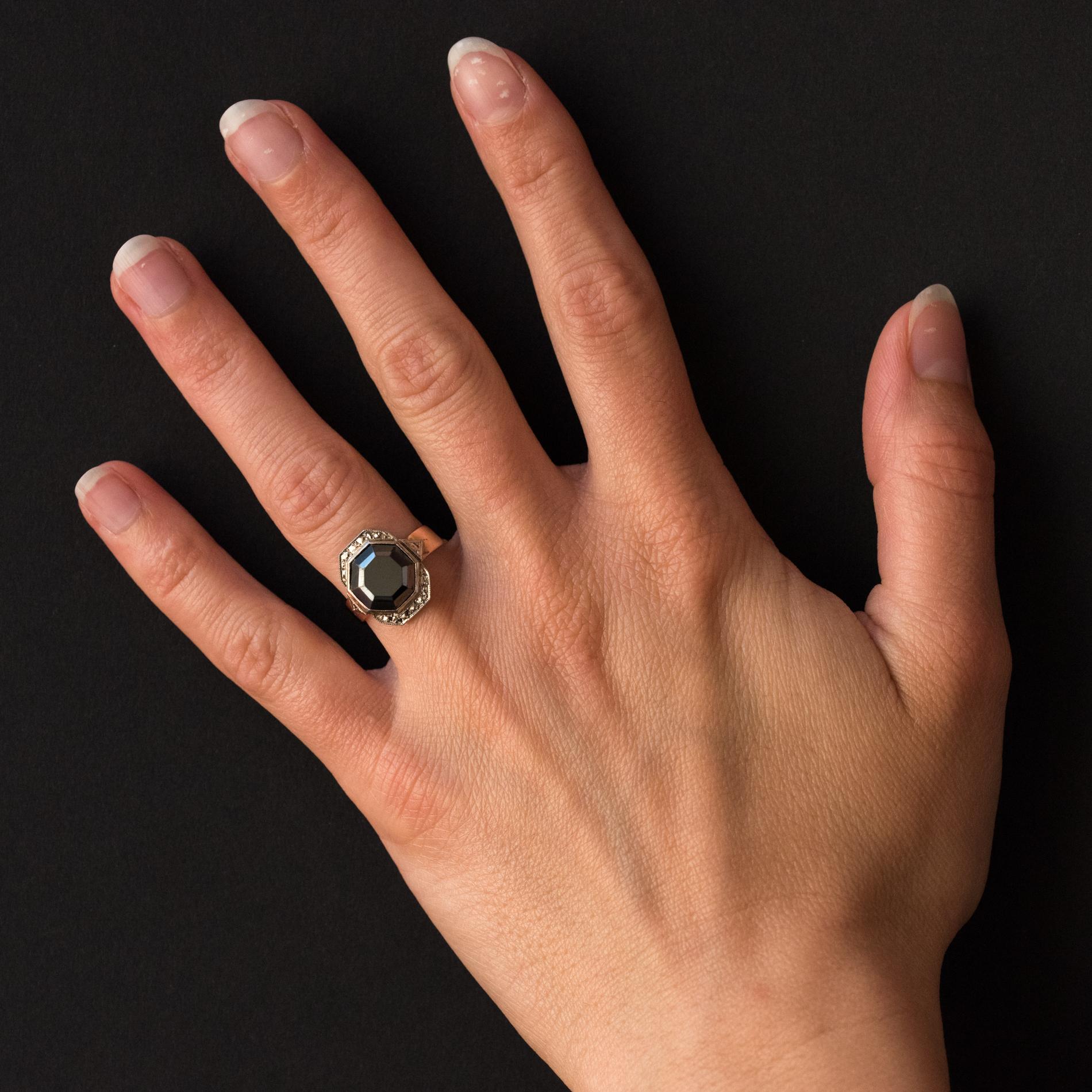 Ring in 18 karat rose gold.
Lovely antique ring, it is closed set in the center of an octagonal hematite surrounded by a chiseled decoration imitating diamonds. On both sides, the start of the ring is adorned with two chiseled triangular