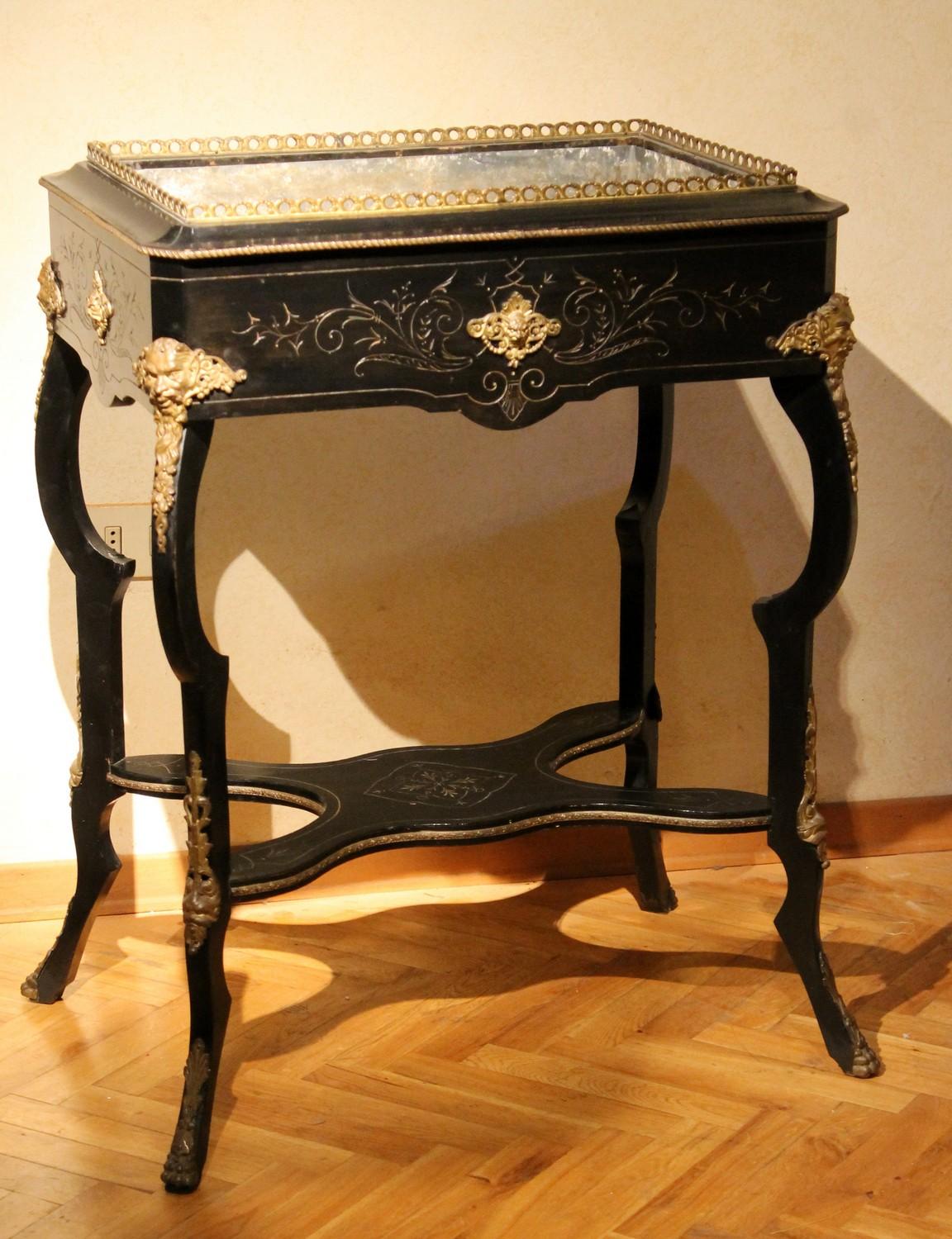 This magnificent French mid-19th century Napoleon III period free standing planter table exhibits detailed craftsmanship, a blackened wood jardinière with pen work inlay and finely chiseled gilt bronze mounts throughout.
The rectangular tabletop -