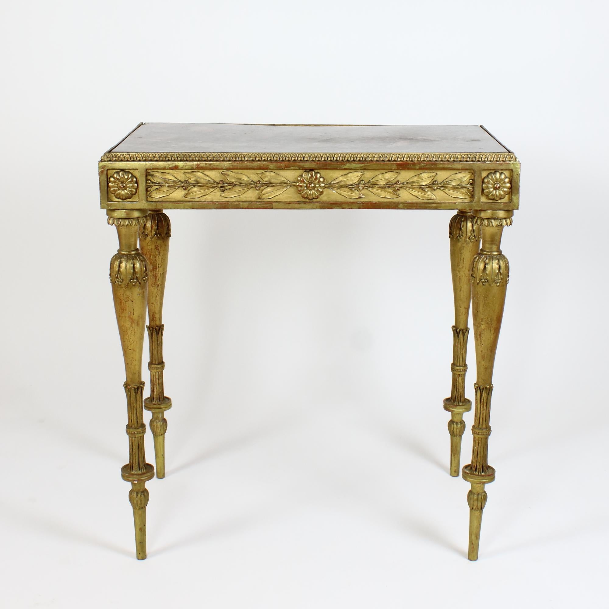French 19th Century Napoleon III / Louis XVI Style Giltwood Center Table

A rectangular table made of gilded wood is resting on four slender richly sculpted spindle shaped legs with lanceolate leaf decration. The front and both sides decorated with