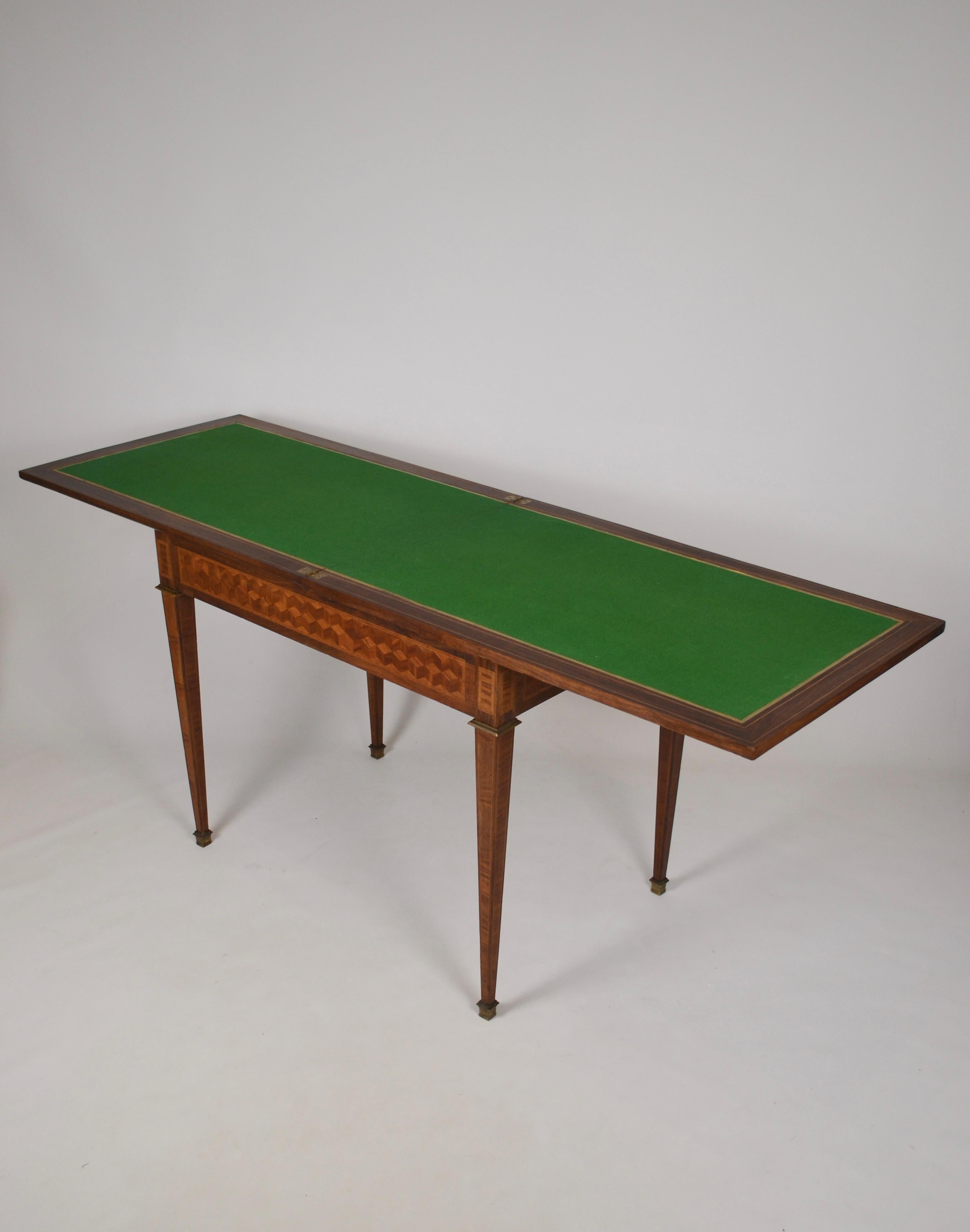 Refined French game table from the second half of the 19th century, crafted in the Napoleon III period with exquisite geometric marquetry and delicate bronze mounts.
The ingenious design combines a wallet-style fold-over opening with a sliding