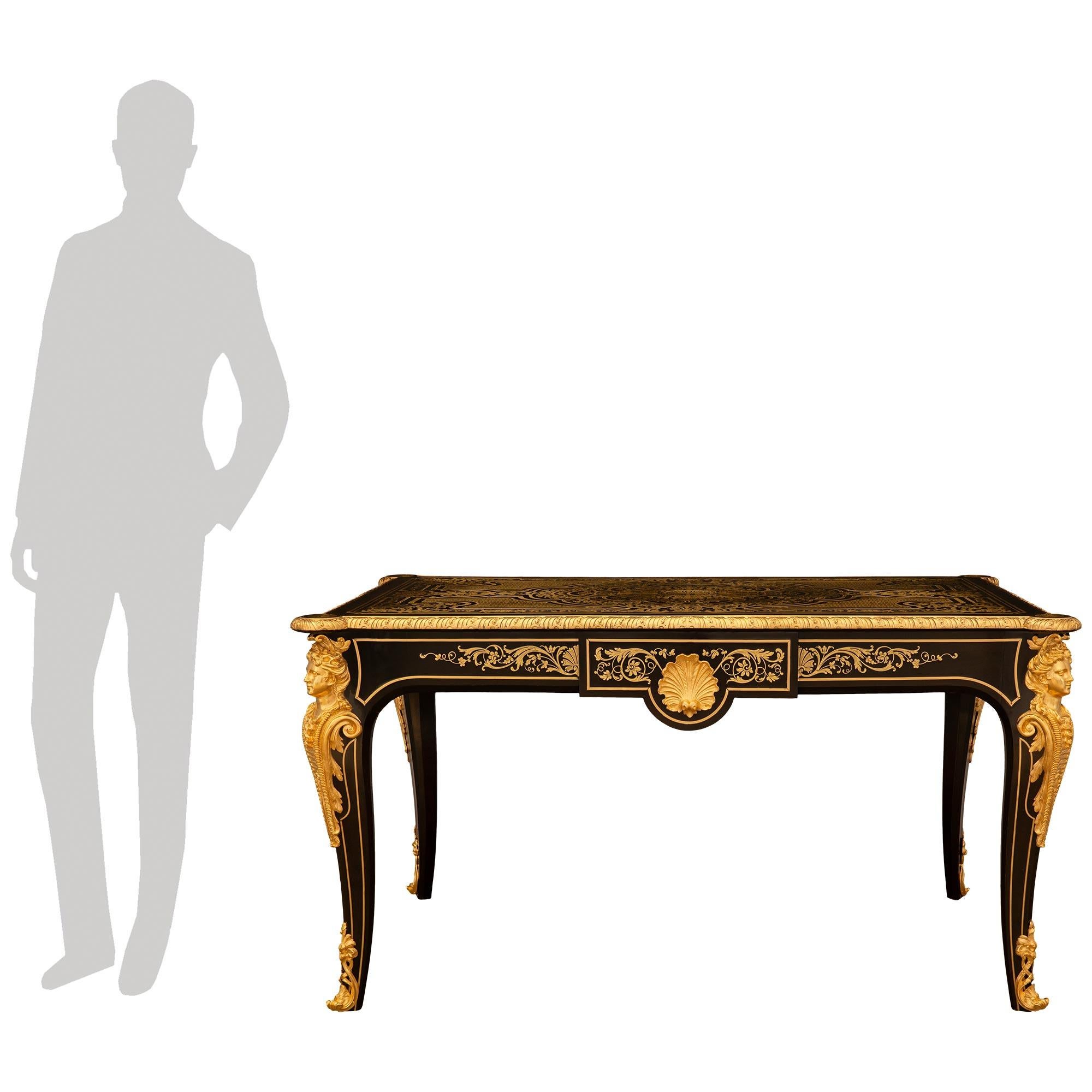 Uno straordinario e impressionante scrittoio francese del 19° secolo, periodo Luigi XV, Napoleone III, in ebano, ottone e ormolu, attribuito a Befort Jeune. Questa scrivania rettangolare di alta qualità è sollevata da splendide gambe cabriole con