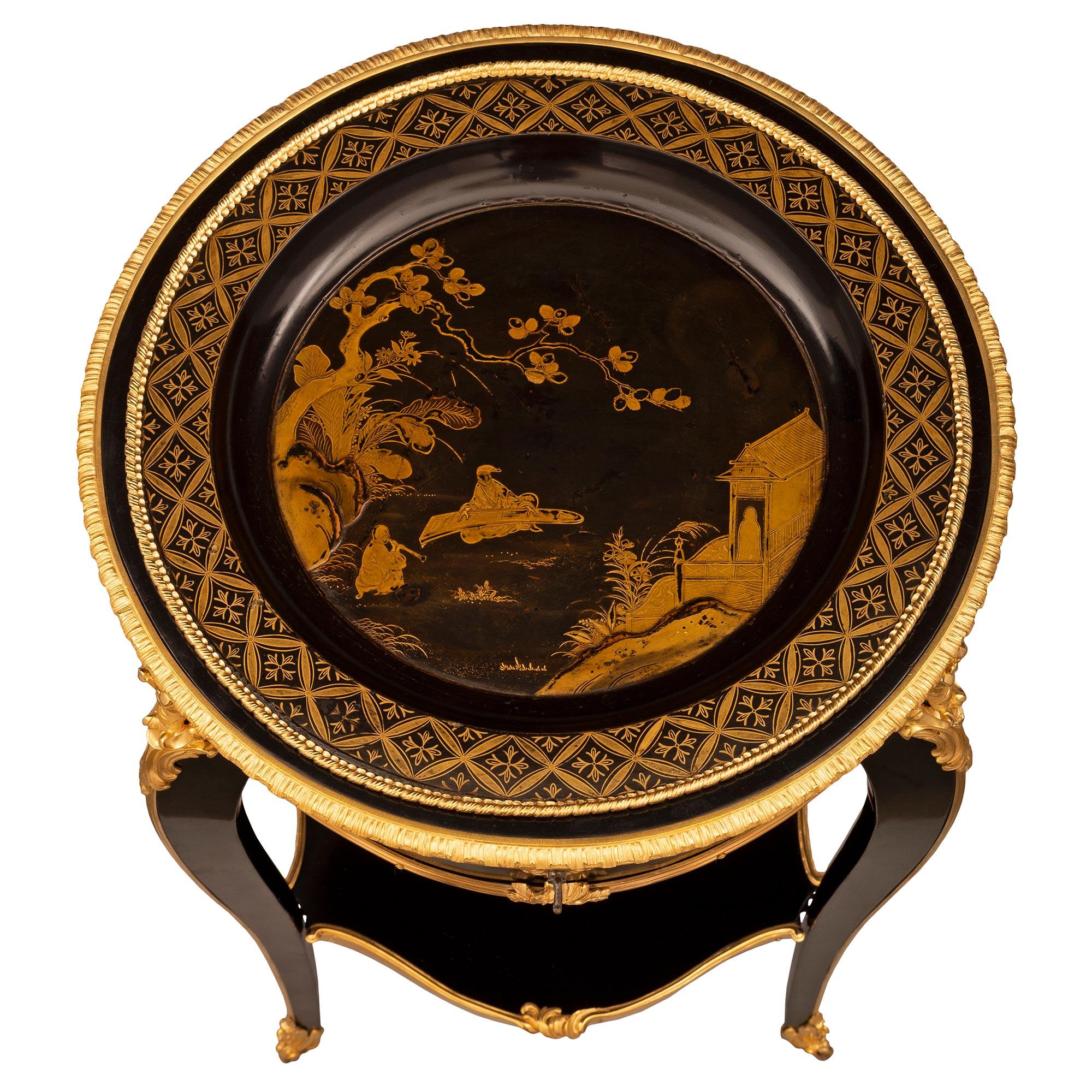 An exquisite French 19th century Louis XV st. Napoleon III period Ebony, ormolu, and Japanese black lacquer side table. The table is raised by three most elegant cabriole legs retaining their original casters below richly chased acanthus leaf fitted