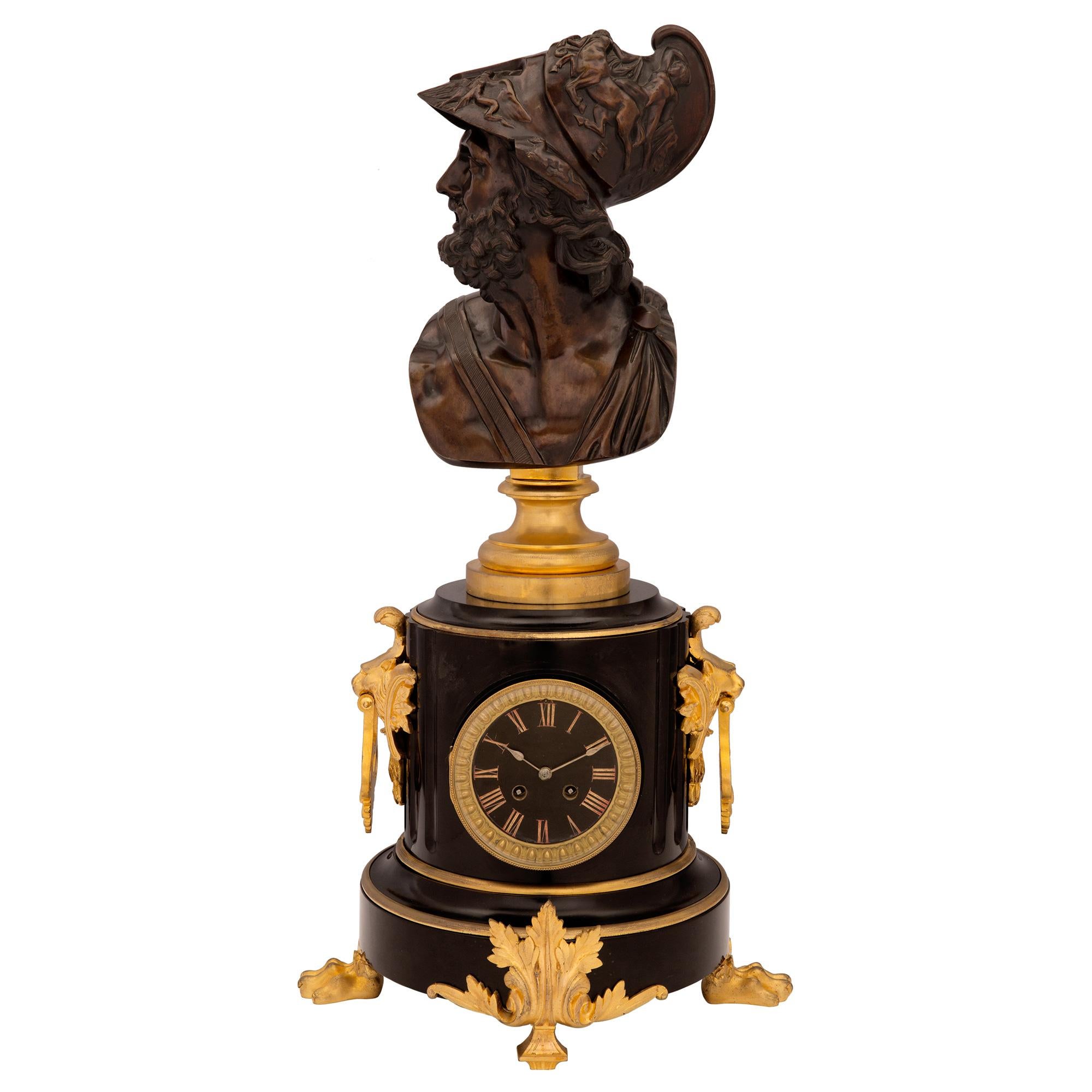A handsome and high quality French 19th century Napoleon III period black Belgian marble, ormolu and patinated bronze garniture set. The three piece set displays two outer tazzas and a central clock with an impressive bust on top. Each patinated