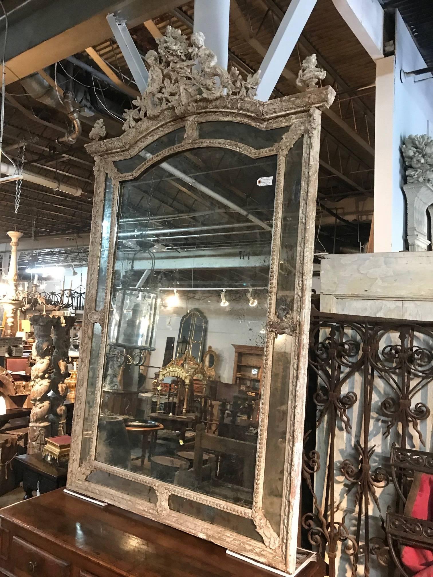 A sensational grand scale Napoleon III period mirror is painted wood. Fantastic carving detail throughout. A stunning piece!