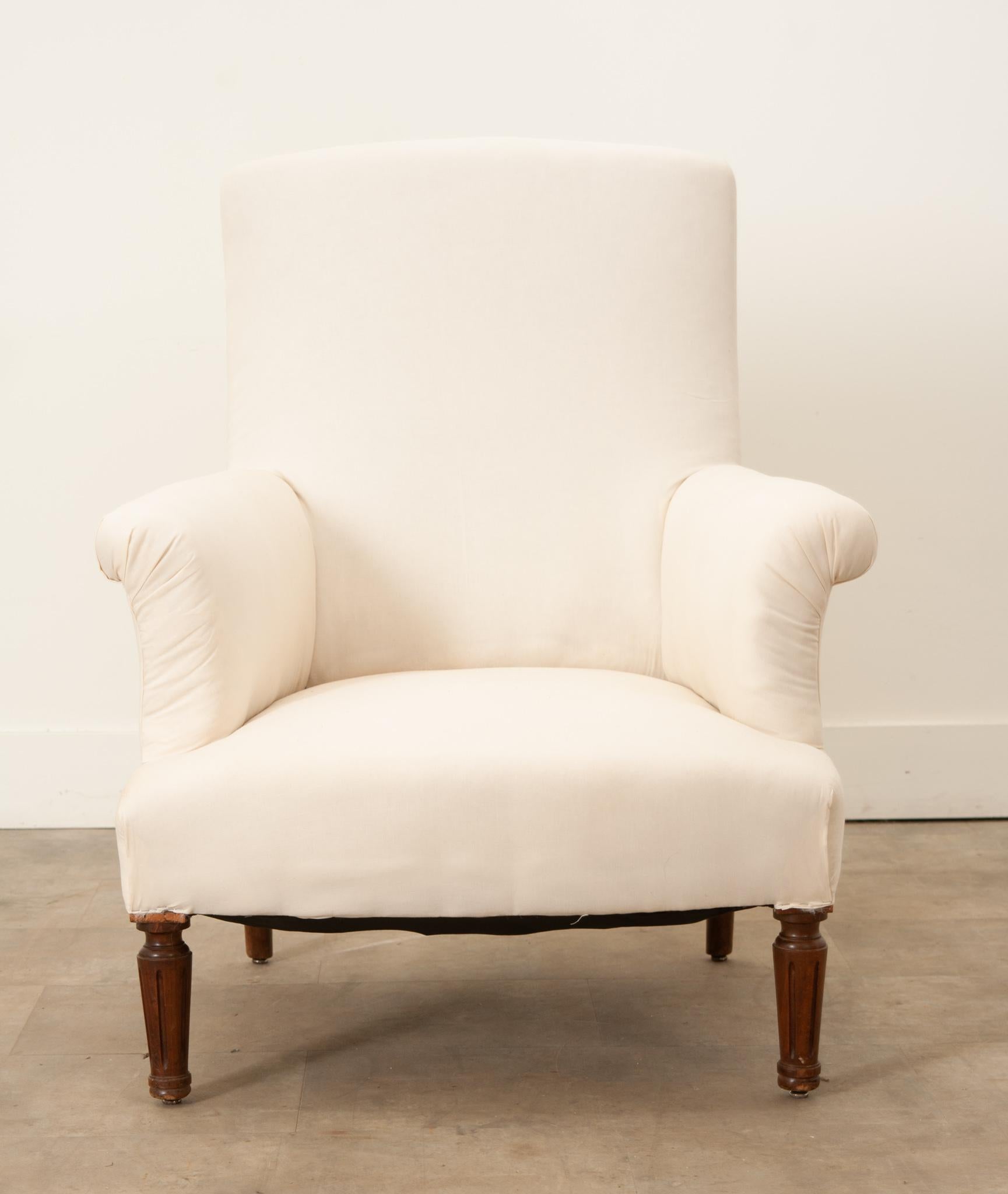This handsome armchair was crafted in 19th century France from solid oak and recently upholstered in a creamy ivory fabric.The fabric is tightly secured to the frame with staples and is ready for new upholstery that pairs with your interior or a