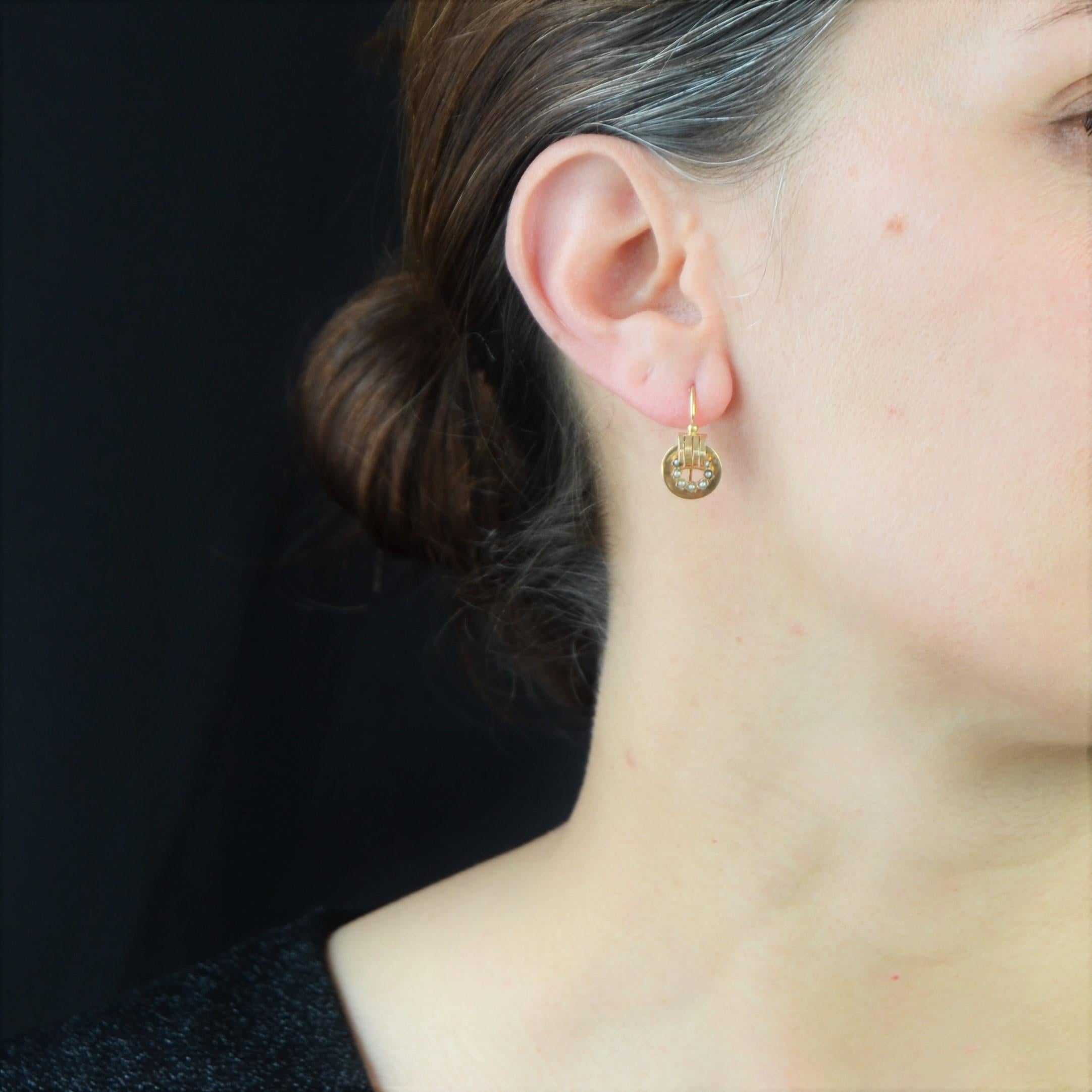 For pierced ears.
Earring in 18 karat rose gold, horse head hallmark.
Antique earrings, in the bright rose gold, they are formed of an openwork disc, decorated each one with 7 natural half pearls and a curved and openwork pattern. A small gold pearl