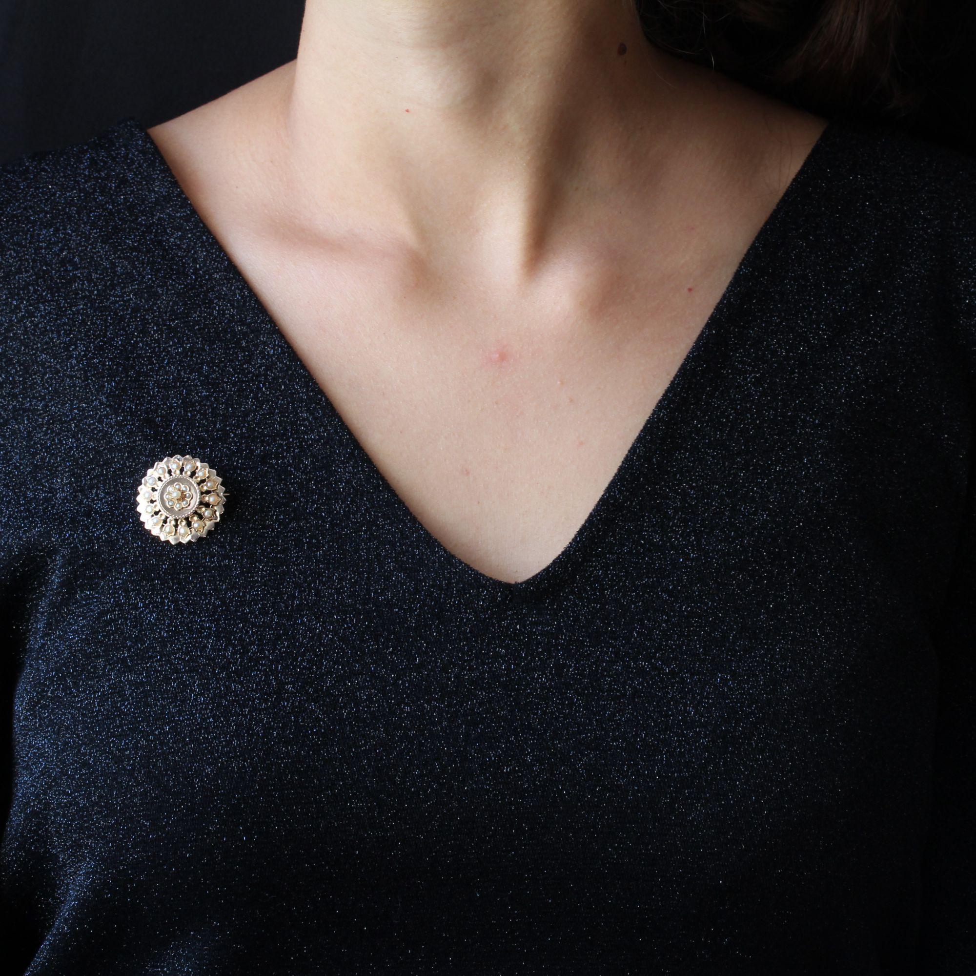 Brooch in 18 karat rose gold, eagle head hallmark.
Of round form, openworked and notched, this charming antique collar brooch is set of half natural pearls on all its turn, and in its center a plate of rose gold supports a daisy pattern, also set of