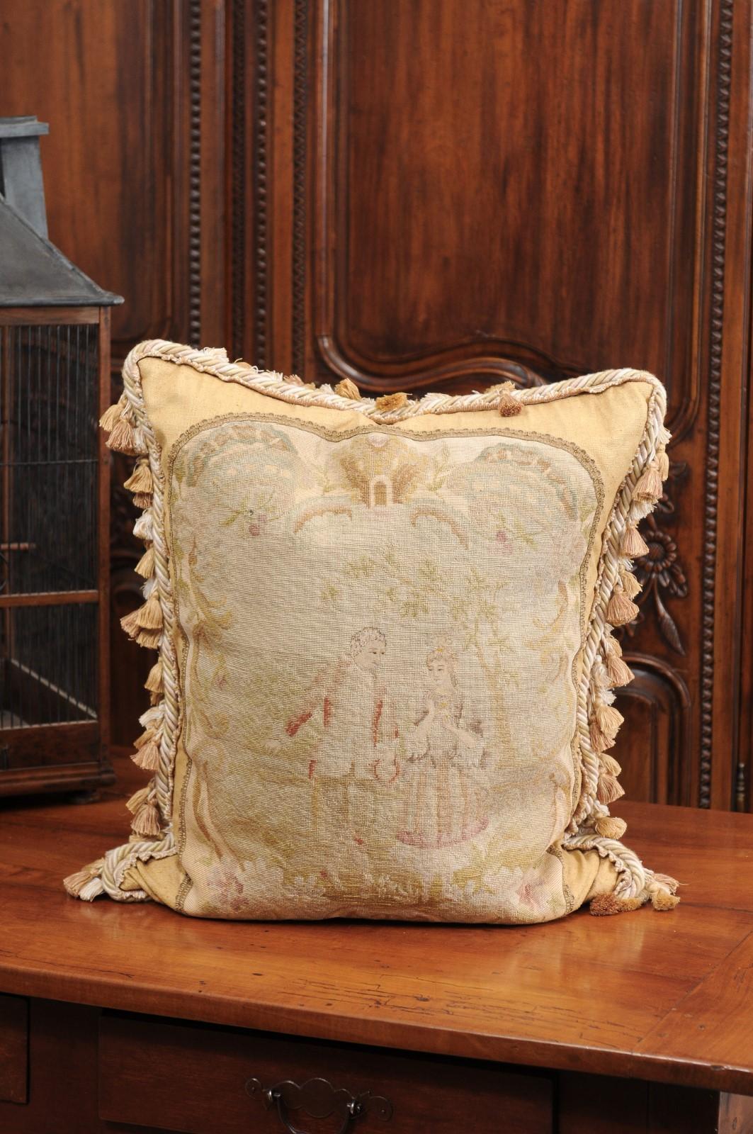 A French needlepoint tapestry pillow from the 19th century, depicting two artistocrates walking in a landscape. Created in France during the 19th century, this needlepoint tapestry pillow charms us with its romantic depiction of a man courting a