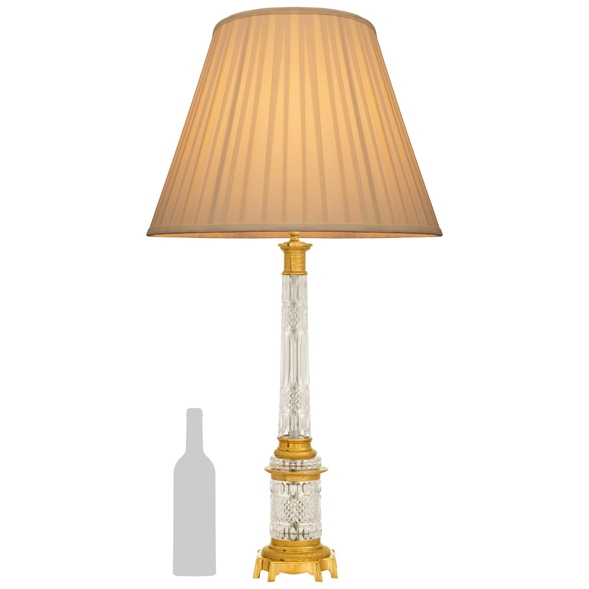 Una squisita lampada neoclassica francese del XIX secolo di alta qualità. Baccarat e Ormolu. Questa imponente lampada è sollevata da una base quadrata a forma di bombee in Ormolu con angoli concavi. Sopra la base c'è una cornice a forma di quarto di