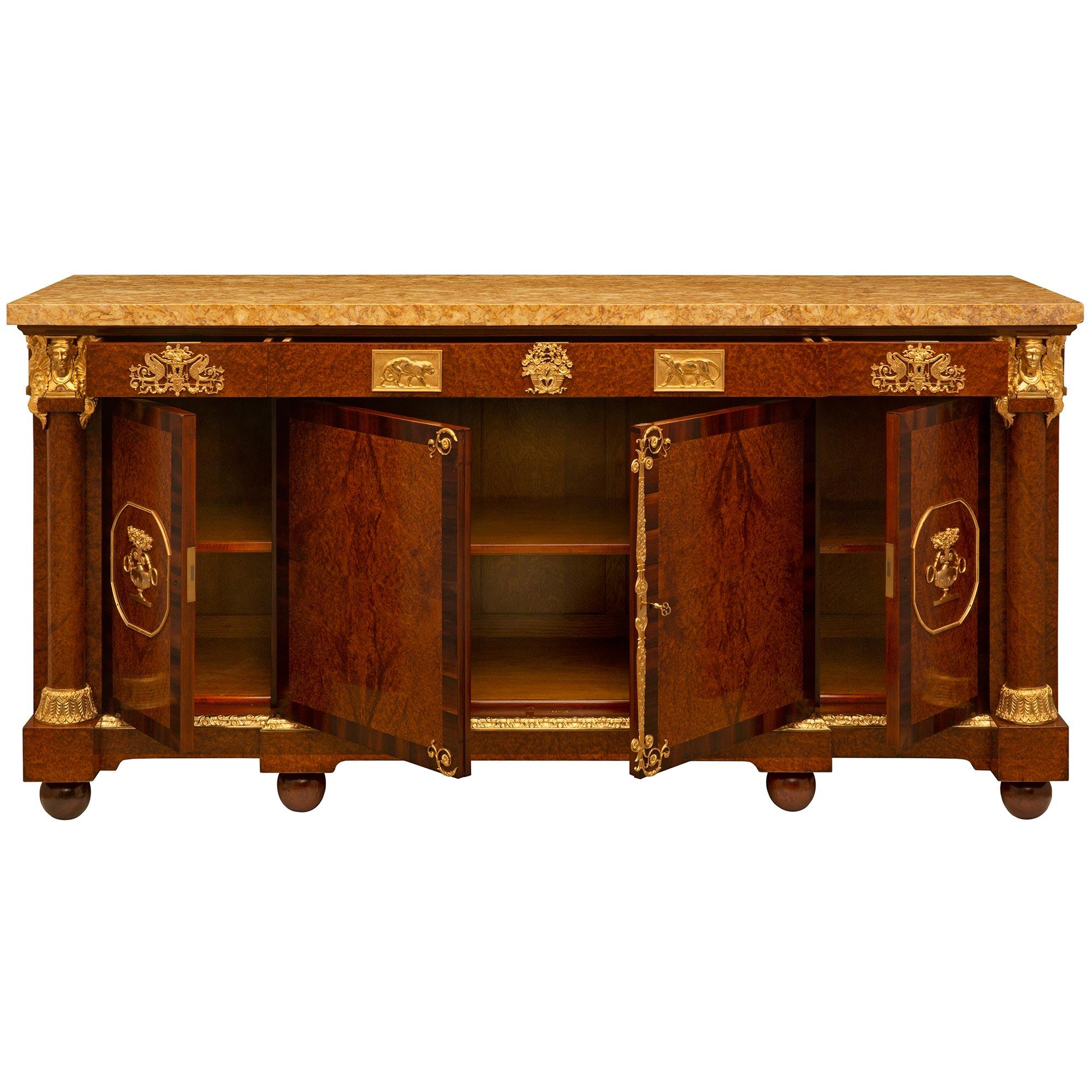 An impressive and extremely high quality French 19th century neo-classical st. burl Walnut, ormolu, and Brocatelle Jaune du Jura marble buffet attributed to Maison Krieger. The four door three drawer buffet is raised by elegant ball feet below a