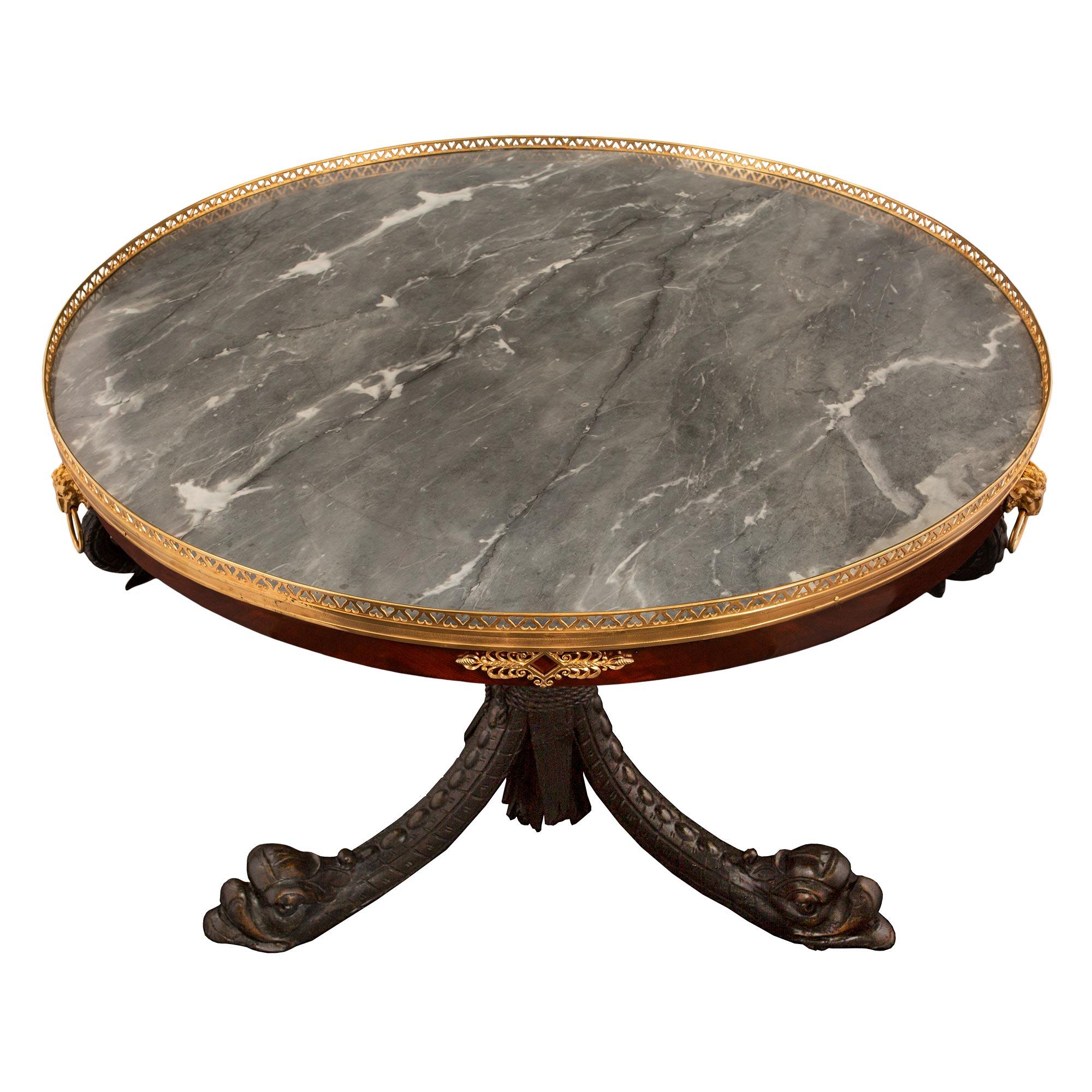 A sensational French 19th century Neo-Classical st. ebonized fruitwood, flamed mahogany, ormolu and marble circular center table, signed Jean Joseph Chapius. The extremely elegant table is raised by its original casters and unique richly carved