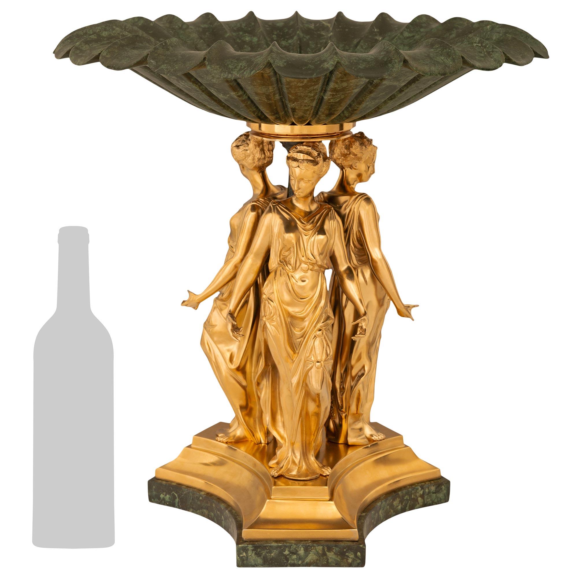 Un élégant centre de table néo-classique français du XIXe siècle de grande qualité, en faux marbre peint, marbre vert et bronze doré. Ce centre de table finement détaillé est surmonté d'une base triangulaire en bronze doré aux bords marbrés et aux