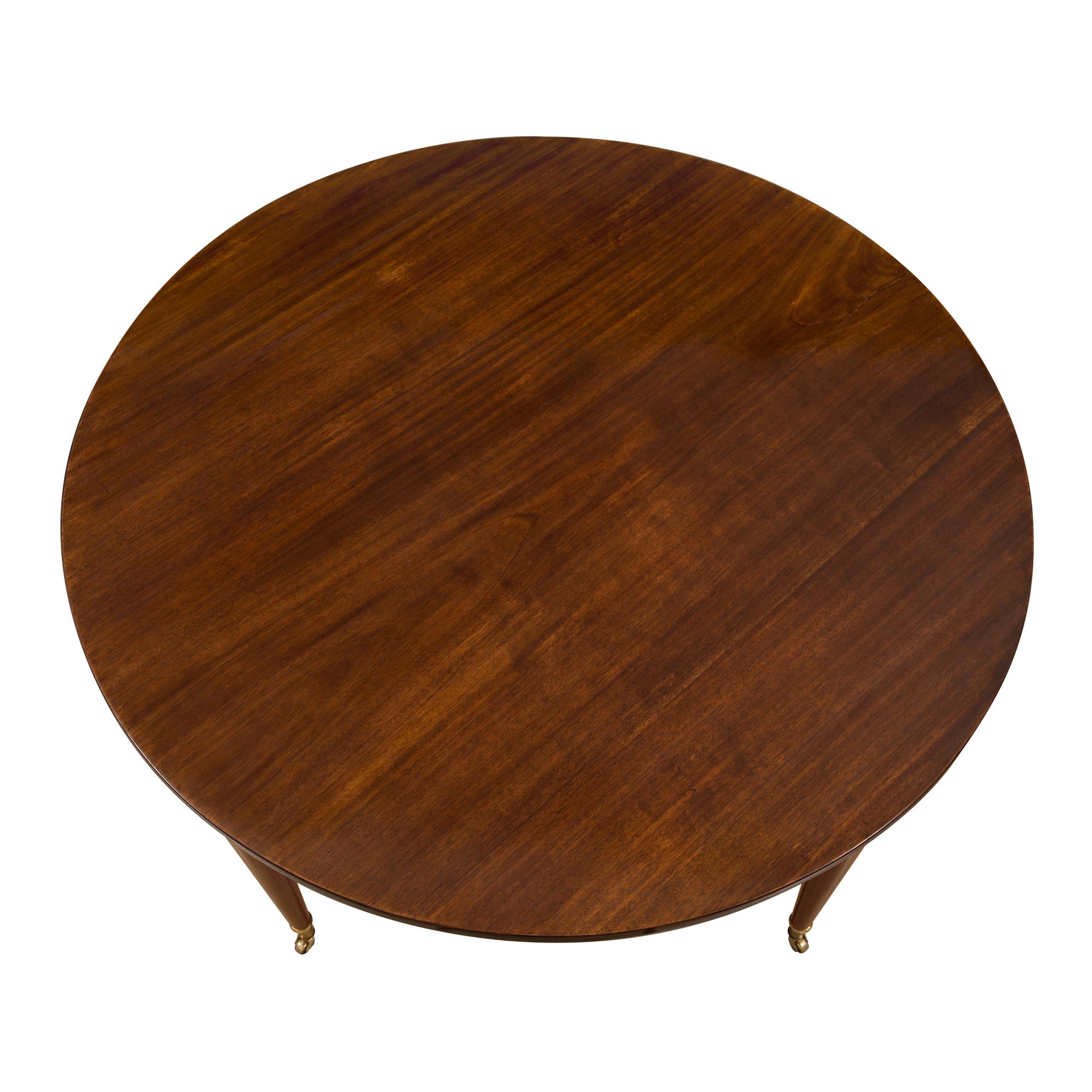 A most elegant French 19th century Neo-Classical st. mahogany center table. The table is raised by fine circular tapered legs with ormolu sabots and their original casters. Above each leg are beautiful ormolu top caps with richly chased foliate and