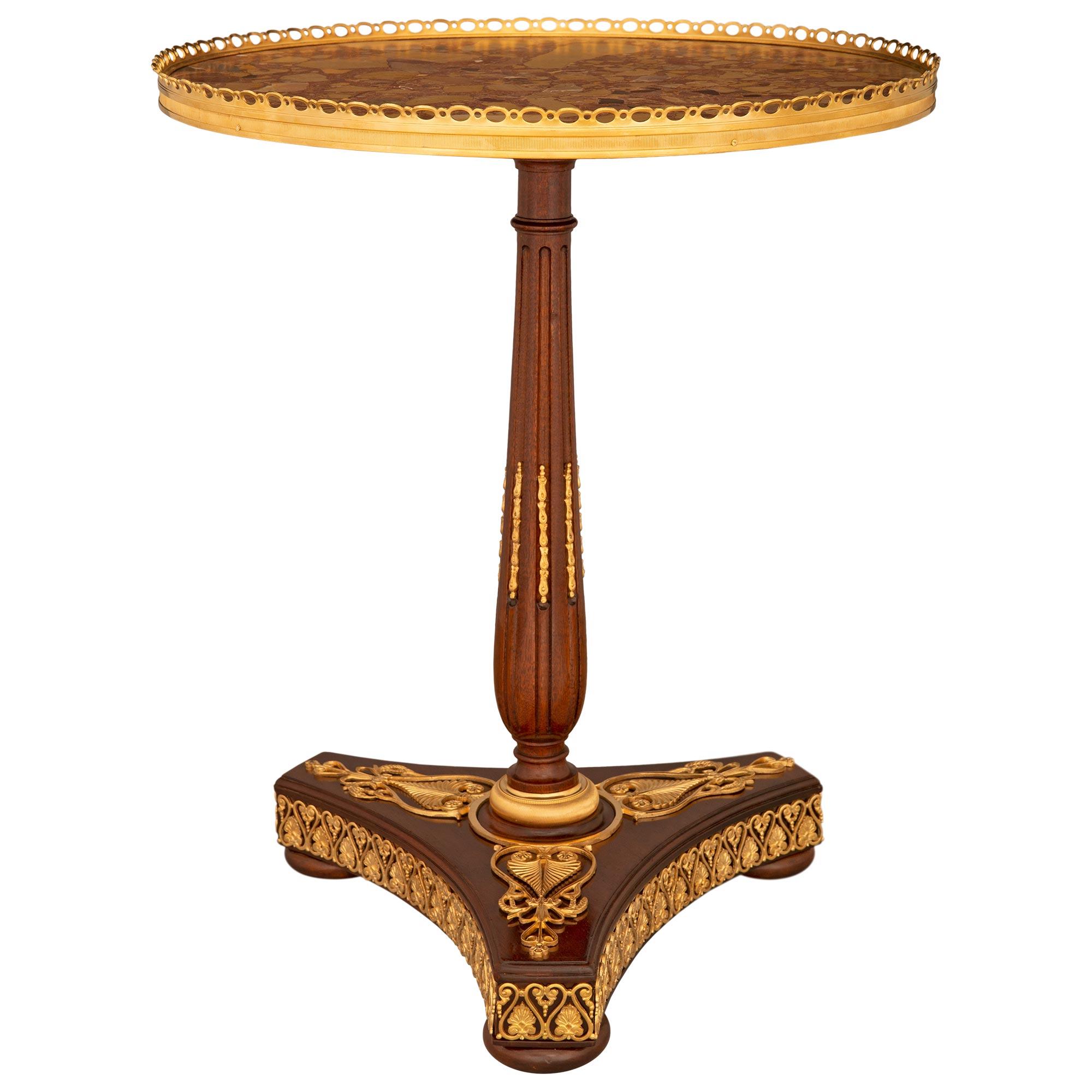 Exceptionnelle table d'appoint en acajou, bronze doré et marbre Brèche d'Alep, de très grande qualité, de style néo-classique français du XIXe siècle. Acajou, bronze doré et marbre Brèche d'Alep. La table circulaire repose sur une base triangulaire