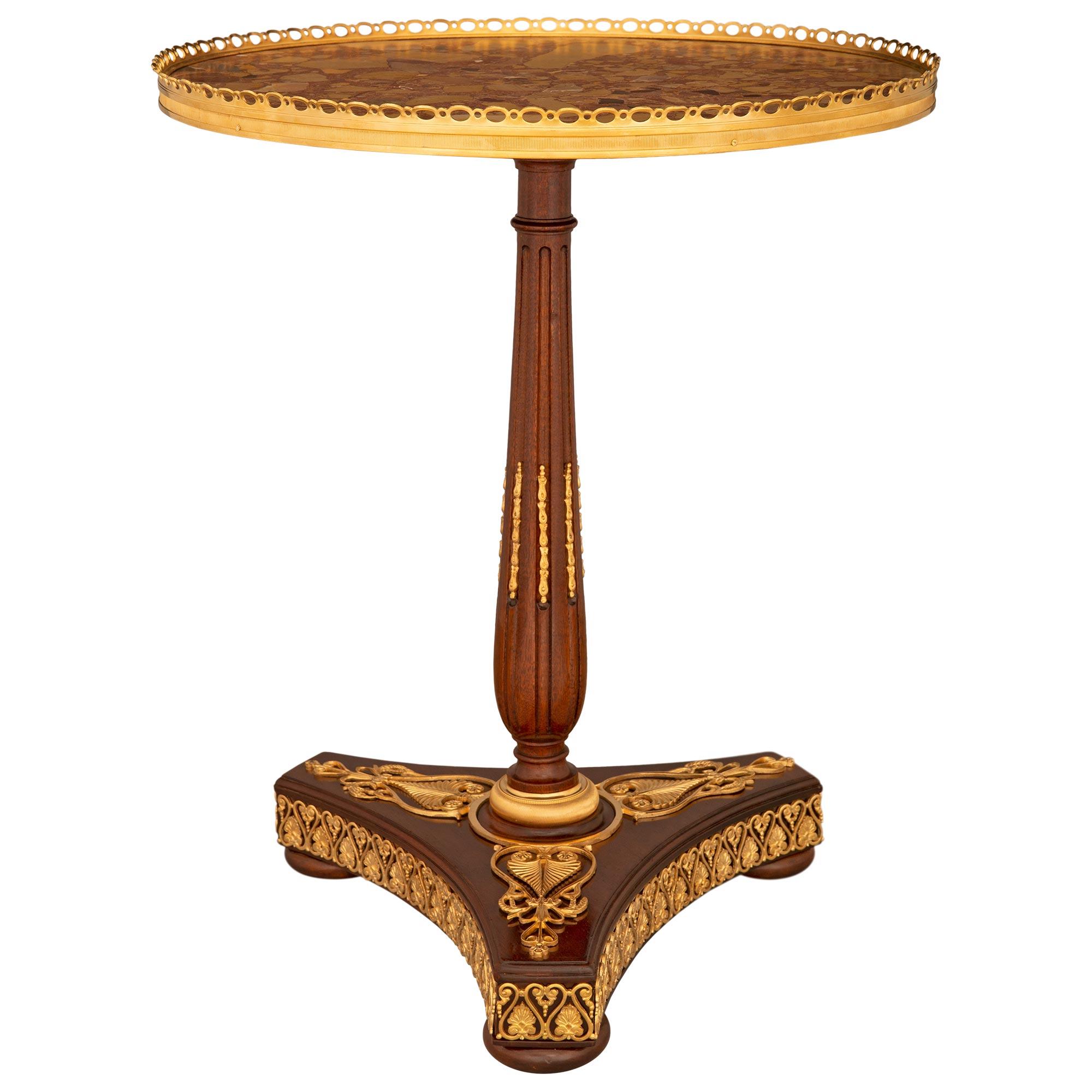 An exceptional and very high quality French 19th century Neo-Classical st. Mahogany, ormolu and Brèche d'Alep marble side table. The circular table is raised by a triangular base with concave sides, cut corners, bun feet and a striking pierced