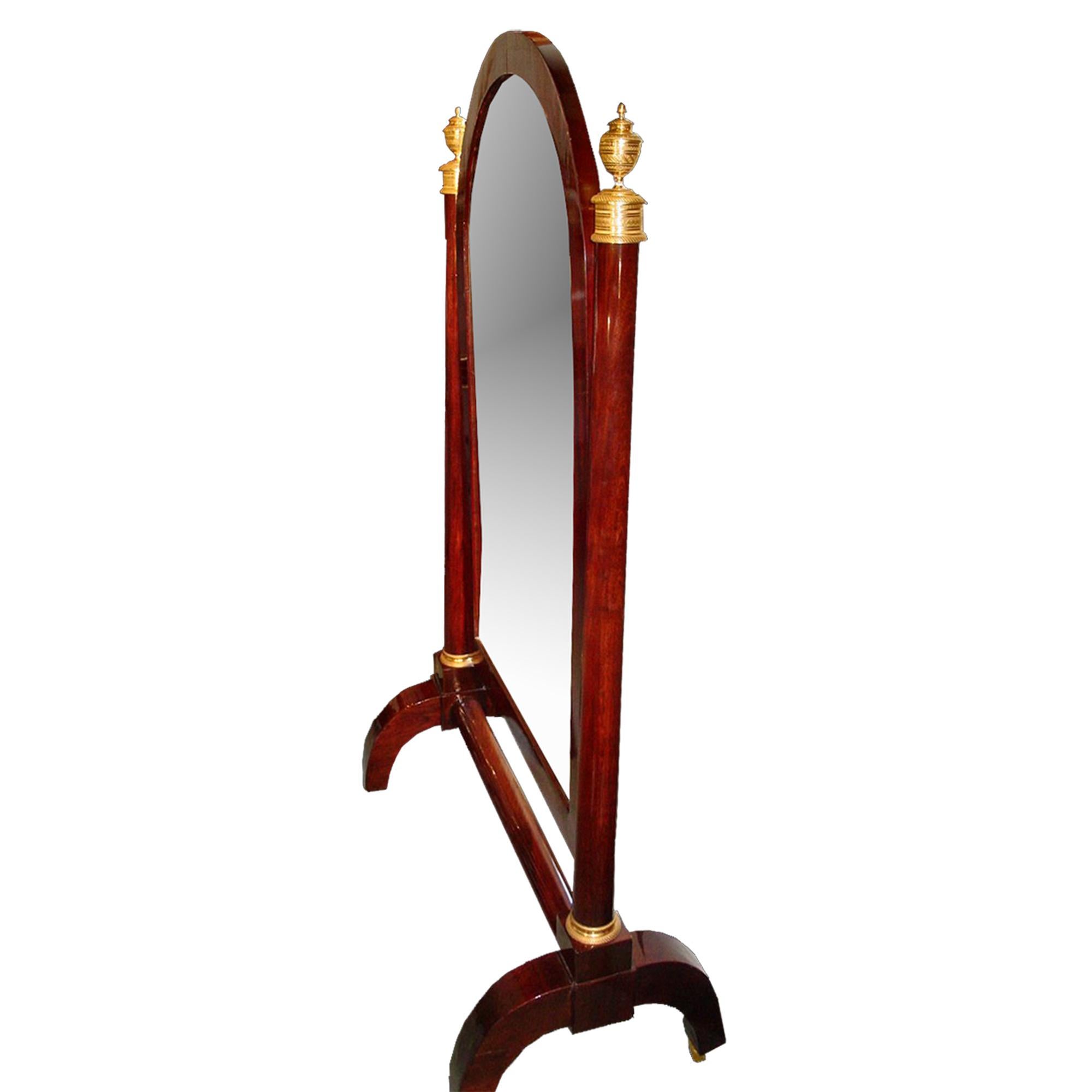 Miroir de Psyché en acajou de style néo-classique français du milieu du XIXe siècle. L'ensemble repose sur quatre pieds à volutes en C munis de roulettes en bronze doré et réunis par une civière cylindrique. Le miroir, dans un cadre en placage de