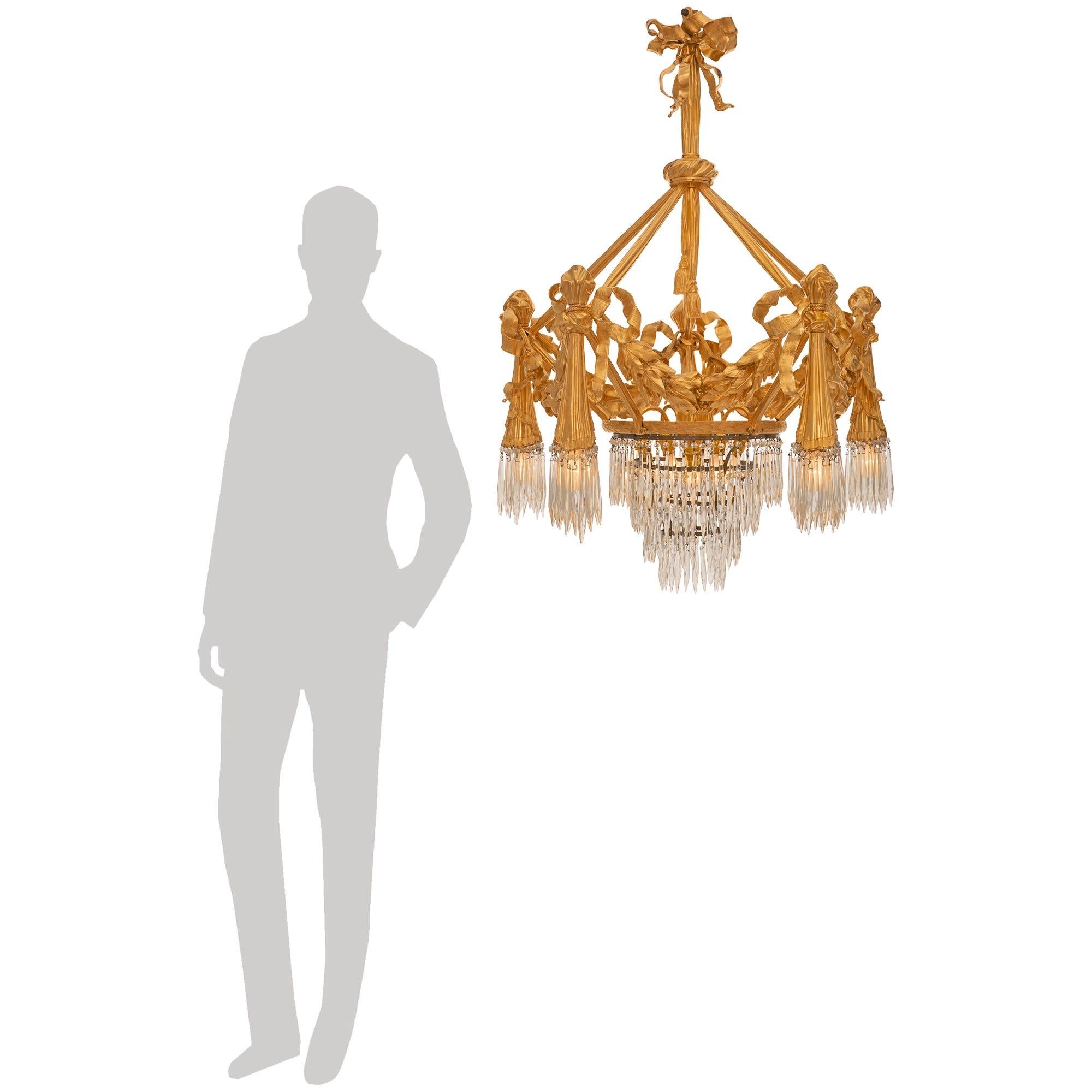 A most impressive and unique French 19th century Neo-Classical st. Ormolu and crystal chandelier. The five arm, ten light chandelier is centered by three stunning tiers of prism shaped crystal pendants below an Ormolu band accented with overlapping