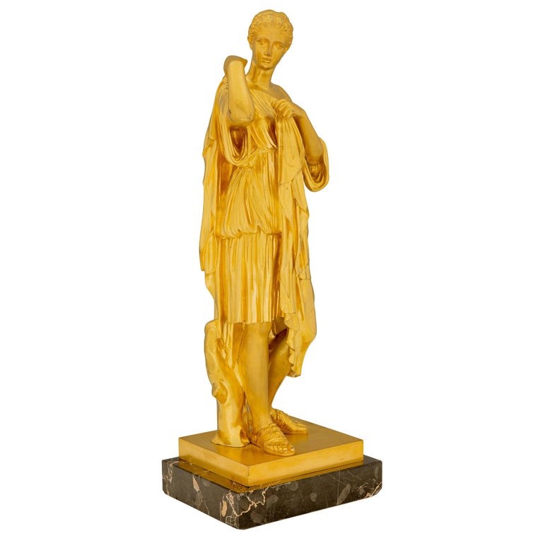 An extremely elegant French 19th century Neo-Classical st. ormolu and Portoro marble statue of a maiden. The statue is raised by a rectangular Portoro marble base where the beautiful maiden is standing next to a tree trunk. She is draped in a
