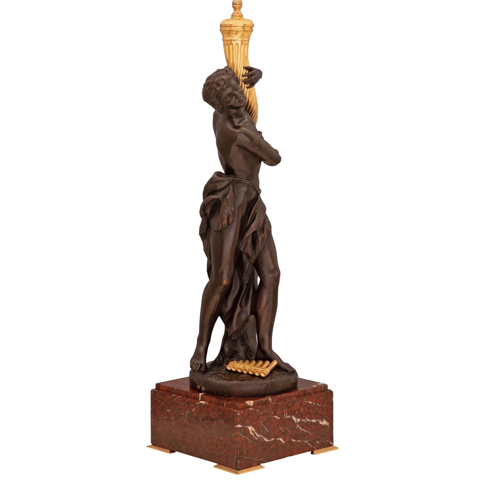 Superbe lampe néo-classique française du 19ème siècle en bronze doré, bronze patiné et marbre Rouge Griotte, signée Clodion. La lampe est surélevée par une impressionnante base carrée en marbre Rouge Griotte avec une fine bordure mouchetée et