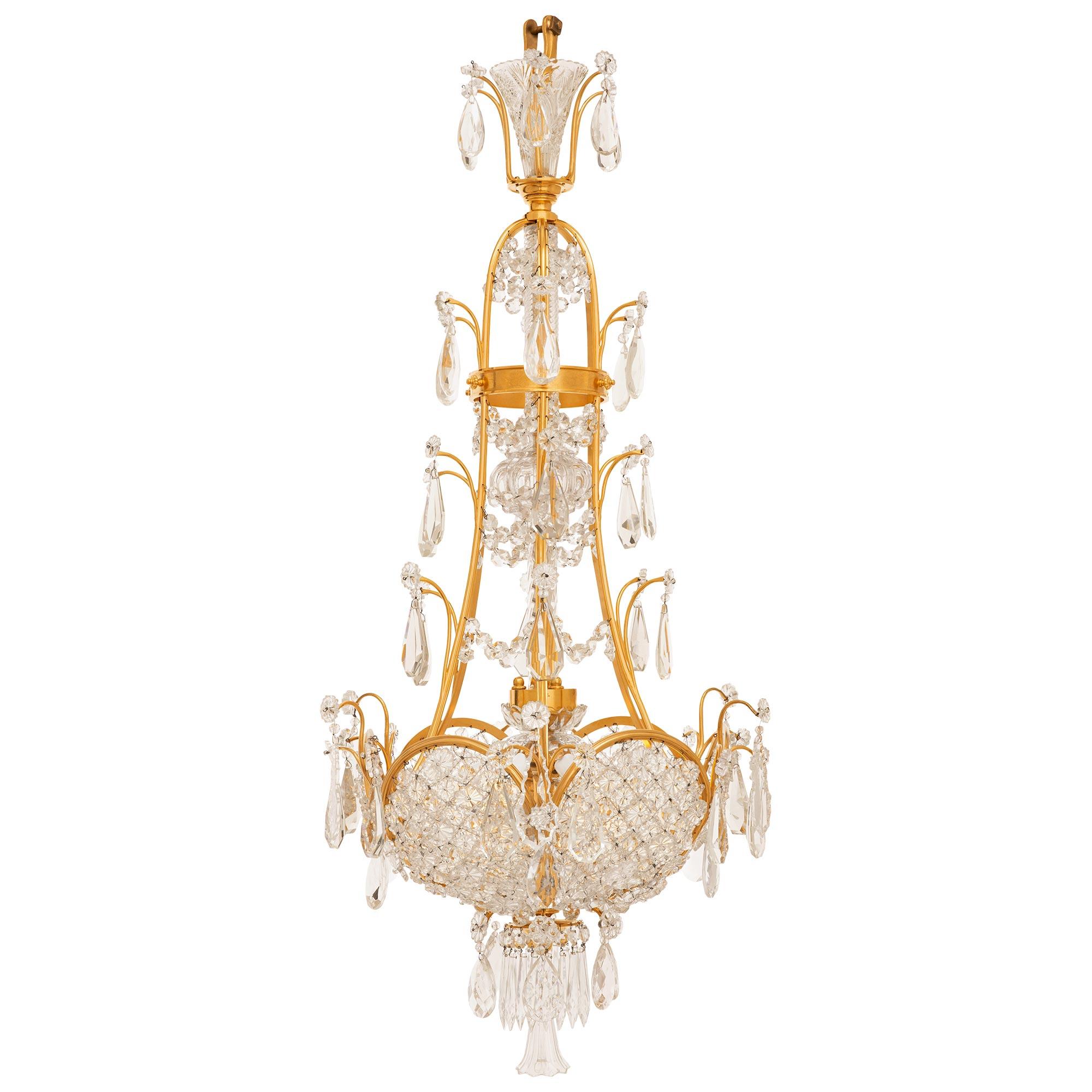 An exceptional and high quality French 19th century Neo-Classical st. Ormolu, Crystal, and Glass chandelier. This wonderful six light chandelier is centered by an inverted tulip bulb bottom finial flanked by prism cut and tear drop cut Crystal