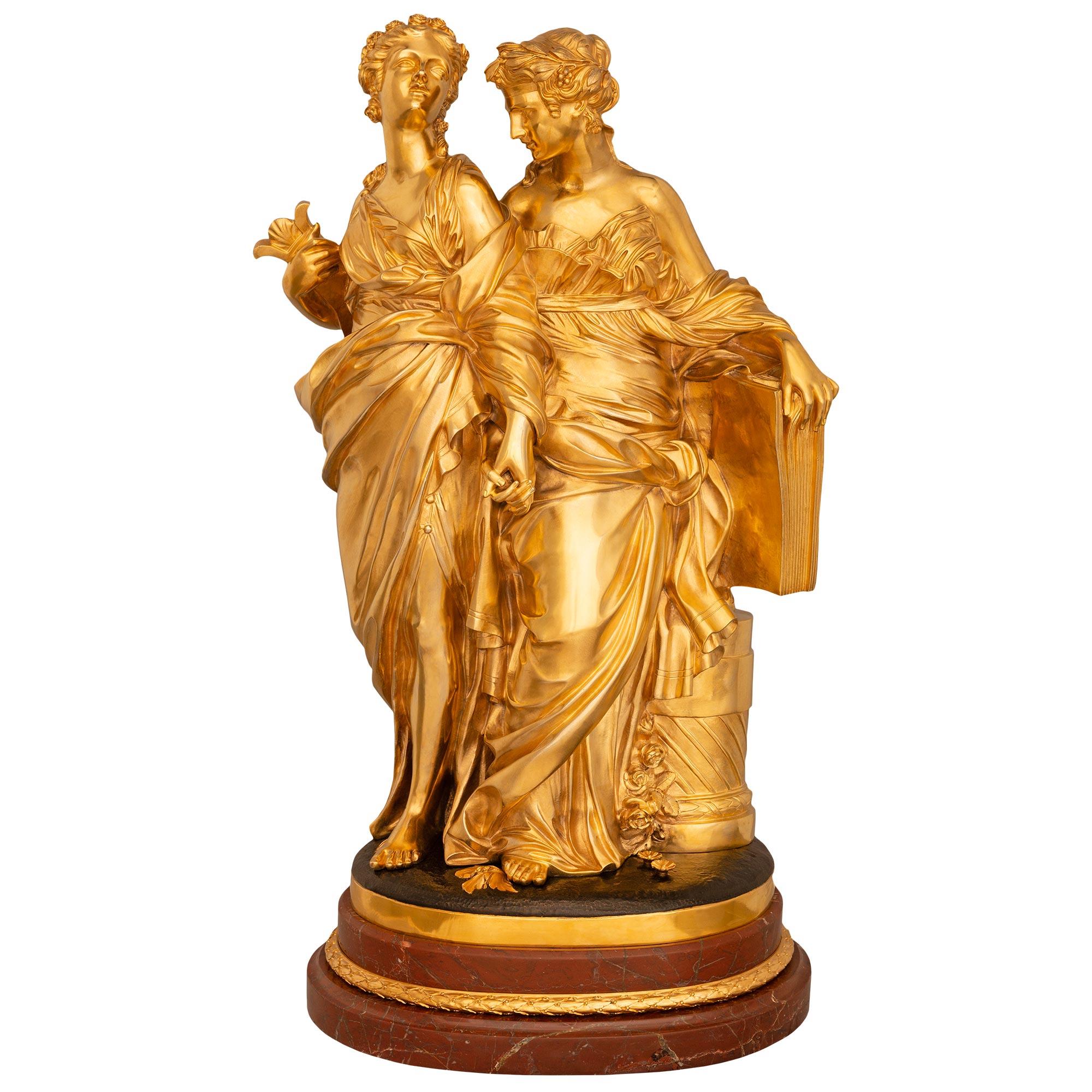 Elegante e di alta qualità, una statua neoclassica francese del XIX secolo. Ormolu, bronzo patinato e marmo Rouge Griotte, firmata Deniére. Questa bellissima statua di Erato e Calliope poggia su una base ovale in marmo Rouge Griotte con bordi
