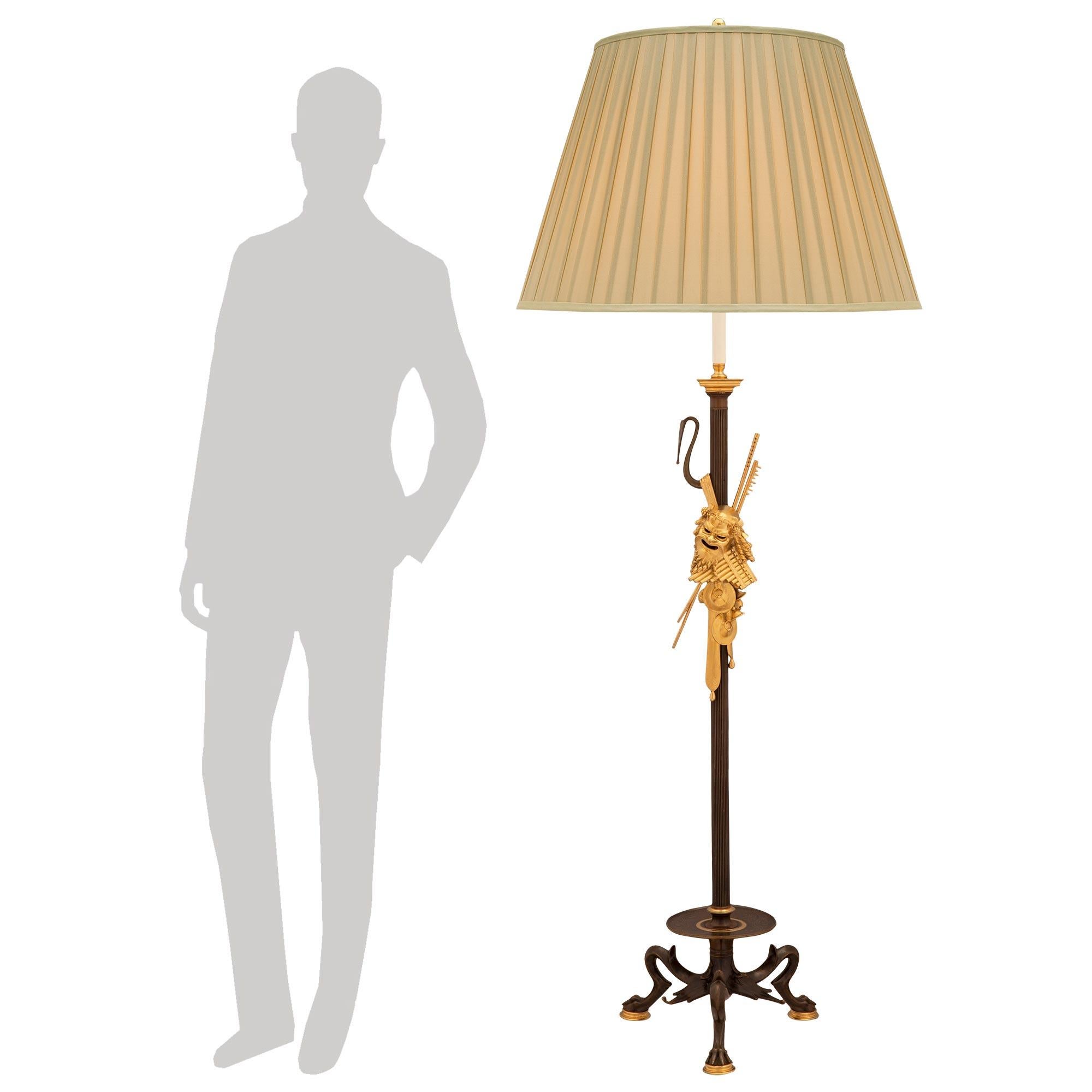 Exceptionnel lampadaire néo-classique français du XIXe siècle en bronze patiné et bronze doré. La lampe est surélevée par trois pieds courbes très décoratifs avec de beaux pieds pattes sur des supports circulaires en bronze doré moucheté. Au-dessus