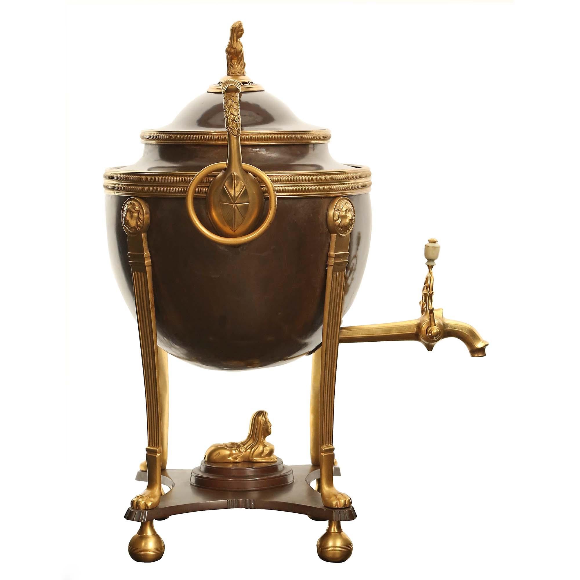 An exquisite French 19th century neo-classical st. patinated bronze and ormolu Samovar. Raised on ormolu ball feet below a bronze tier with concave sides and stepped platform, centered by an ormolu sphinx. Four impressive ormolu fluted supports with
