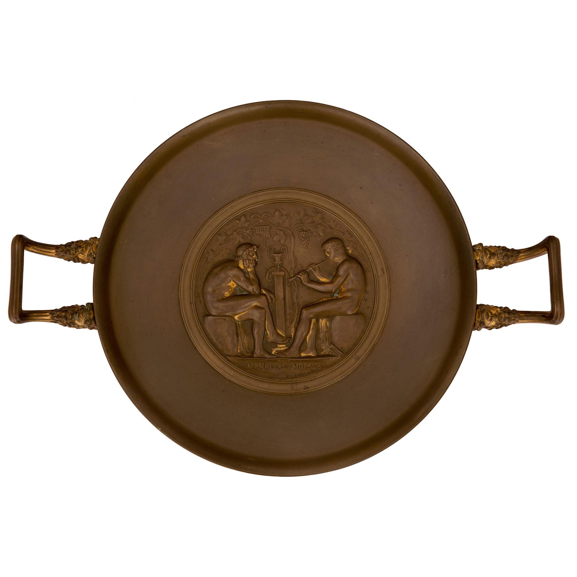 Elegant tazza en bronze patiné de style néo-classique français du XIXe siècle, signé F. Levillain. La tazza est surélevée par une fine base circulaire au dessin lisse en escalier. La coupe circulaire ci-dessus est centrée par une plaque richement
