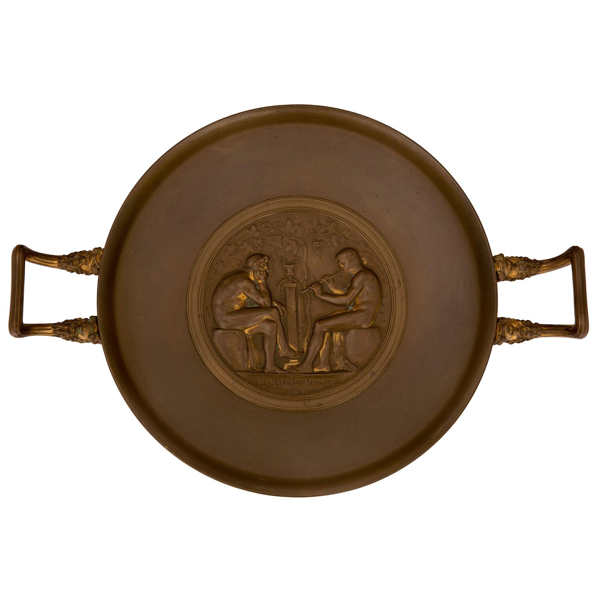 Élégant tazza en bronze patiné de style néo-classique français du XIXe siècle, signé F. Levillain. La tazza est surélevée par une fine base circulaire au design lisse et étagé. La coupe circulaire ci-dessus est centrée par une plaque richement