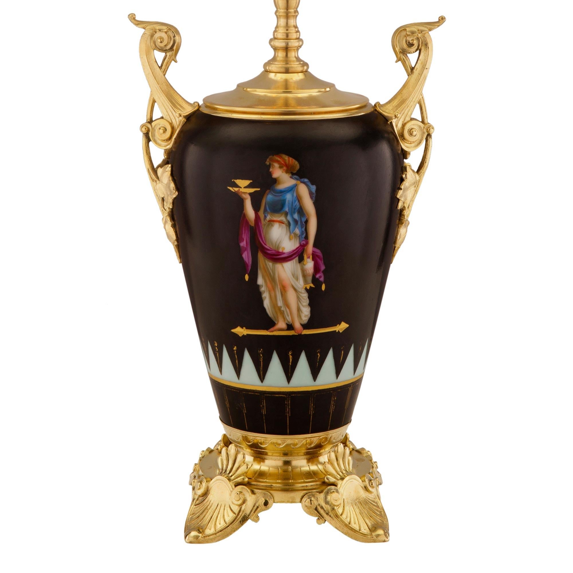 An exceptional French 19th century Neo-Grec st. ormolu and porcelain lamp. The lamp is raised by striking and richly chased palmette designed feet. Above, is the mottled socle pedestal with a fluted design and Vitruvian scrolls. The most decorative