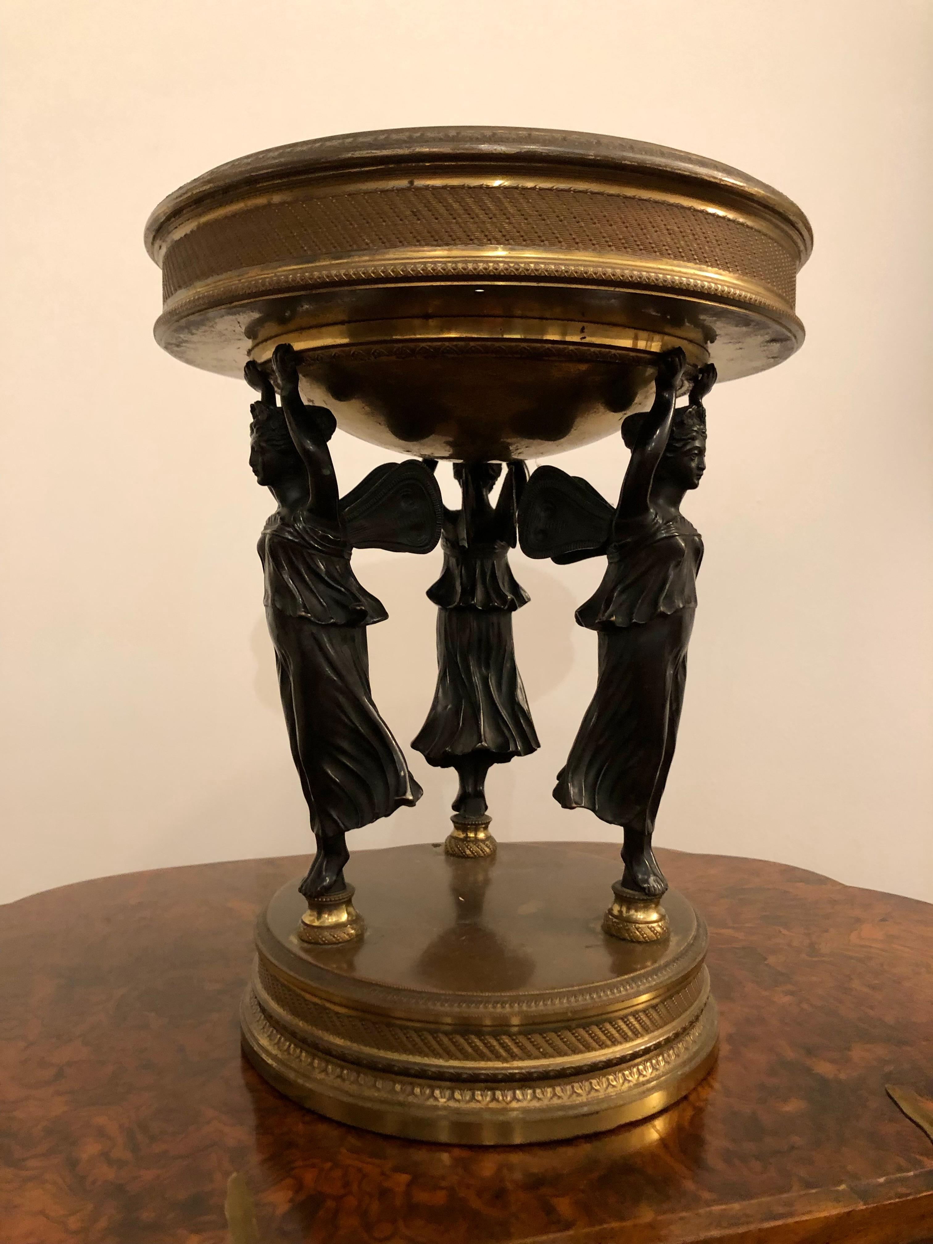 A wonderful French Neoclassical bronze and gilt centrepiece from the nineteenth century.
With three bronze caryatid fairy figures holding gilt brass mounts, likely for larger centrepiece with glass addition.
10.25