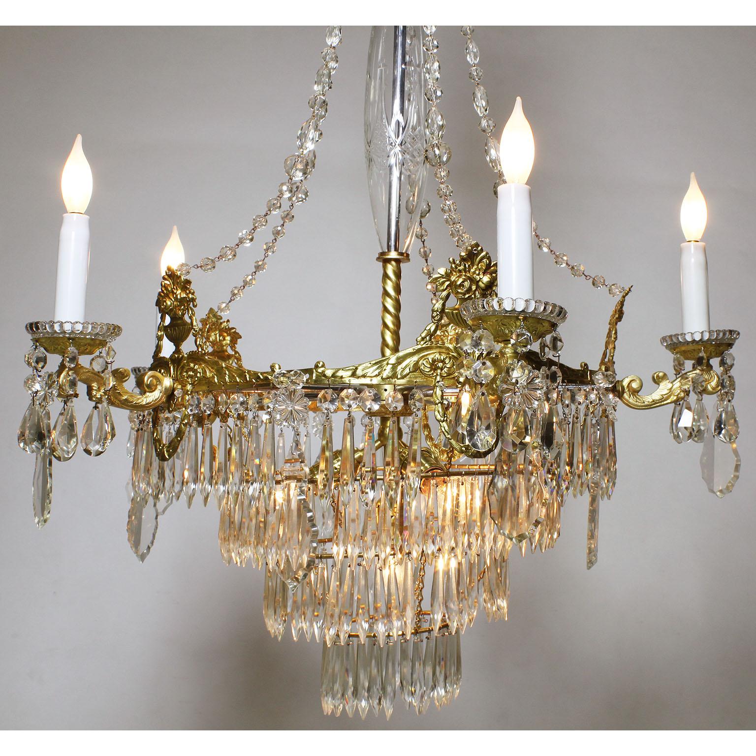 Un beau et rare lustre à cinq lumières en métal doré et prismes en verre taillé, de style néoclassique français du XIXe siècle. Le cadre de style classique est décoré d'urnes florales et surmonté de cinq  Les bras de bougie en forme de 