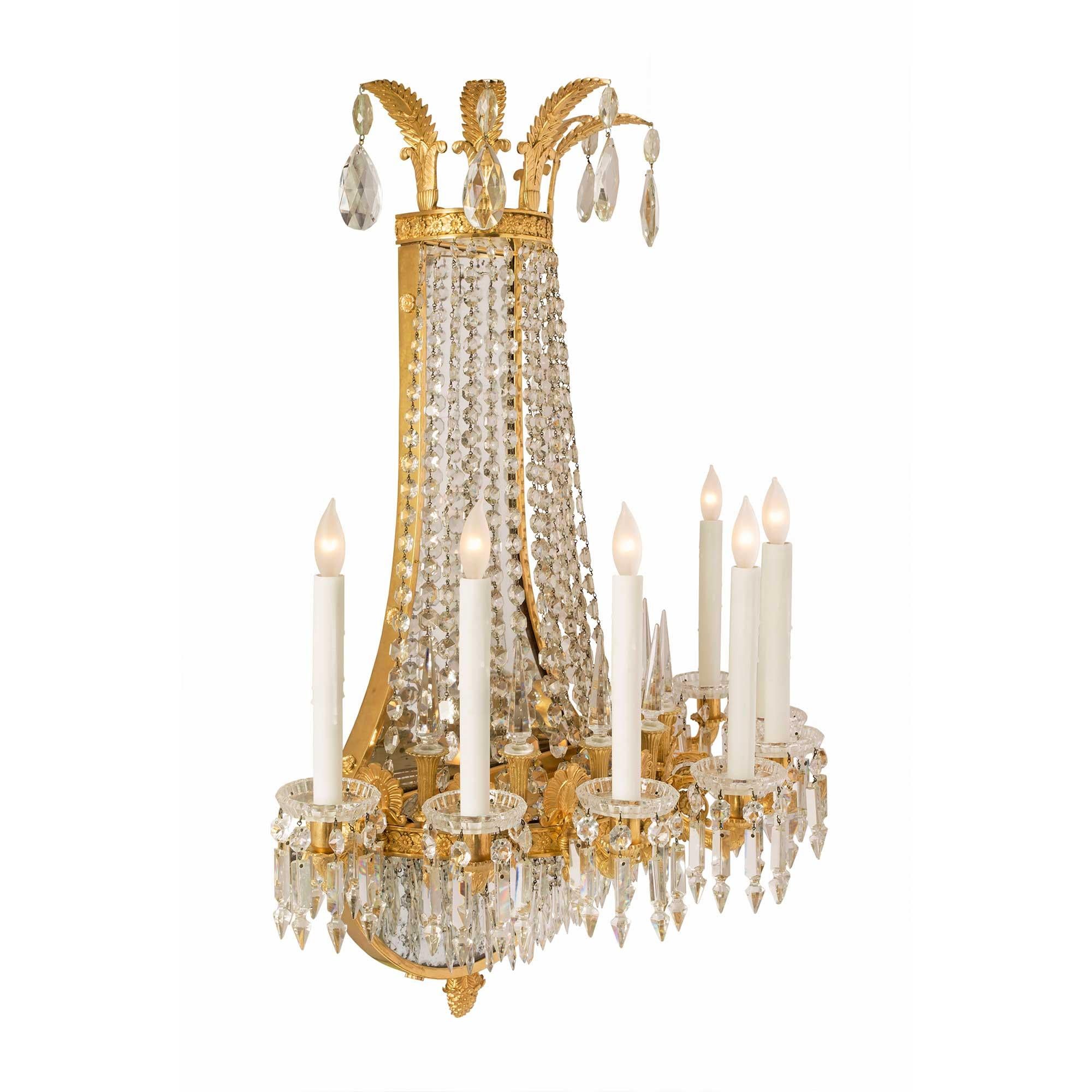 A stunning and monumental pair of French 19th century neo-classical st. ormolu and crystal seven arm, nine-light sconces, signed Baccarat. Each lyre shape sconce is centered by a finely chased ormolu inverted bottom acorn finial, the original mirror