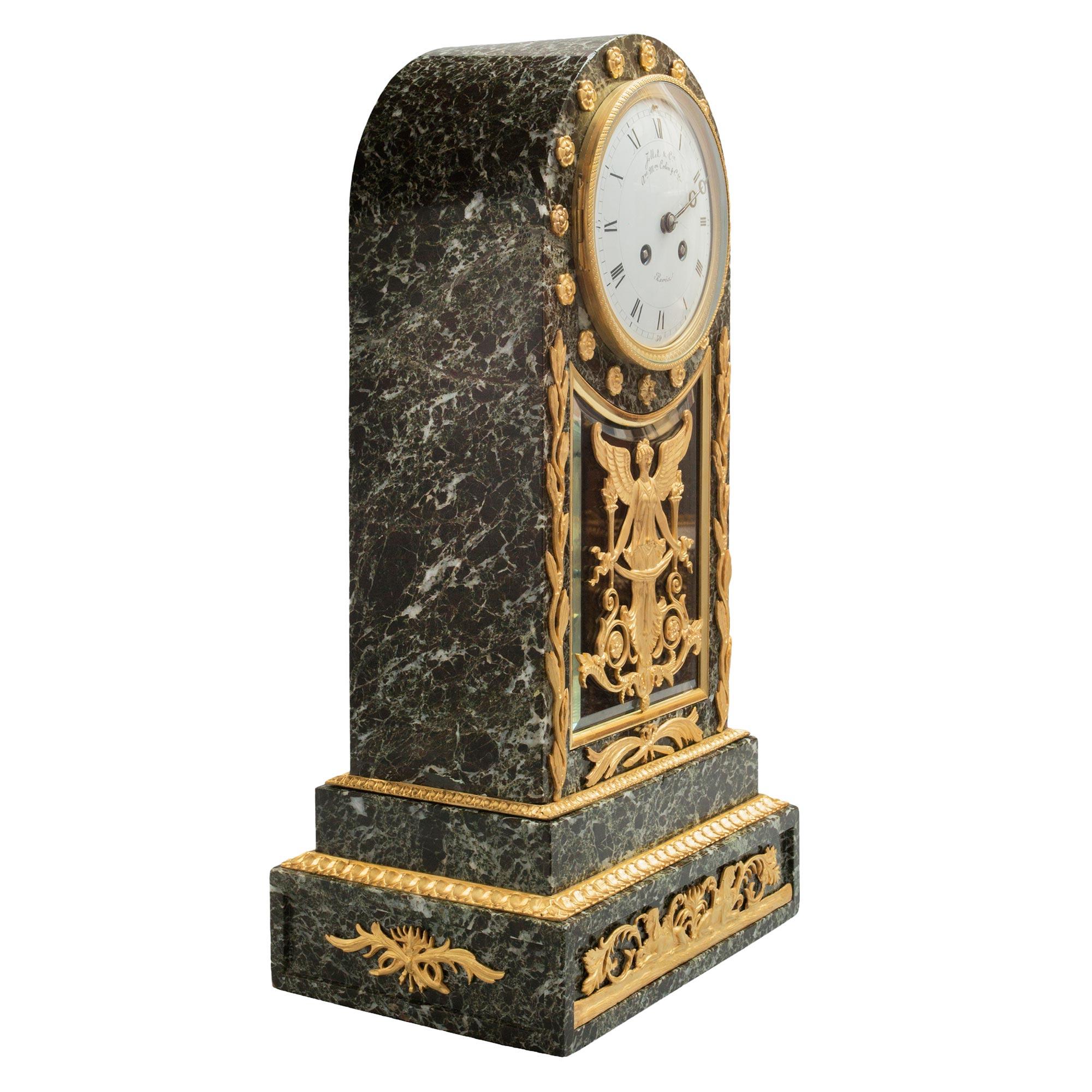 Superbe pendule néo-classique française du 19ème siècle en st. Vert Patricia en marbre et bronze doré, signée Jollet & Cie. L'horloge est surélevée par une base carrée à gradins avec une plaque en bronze ciselé, percé et ajusté à l'avant de deux