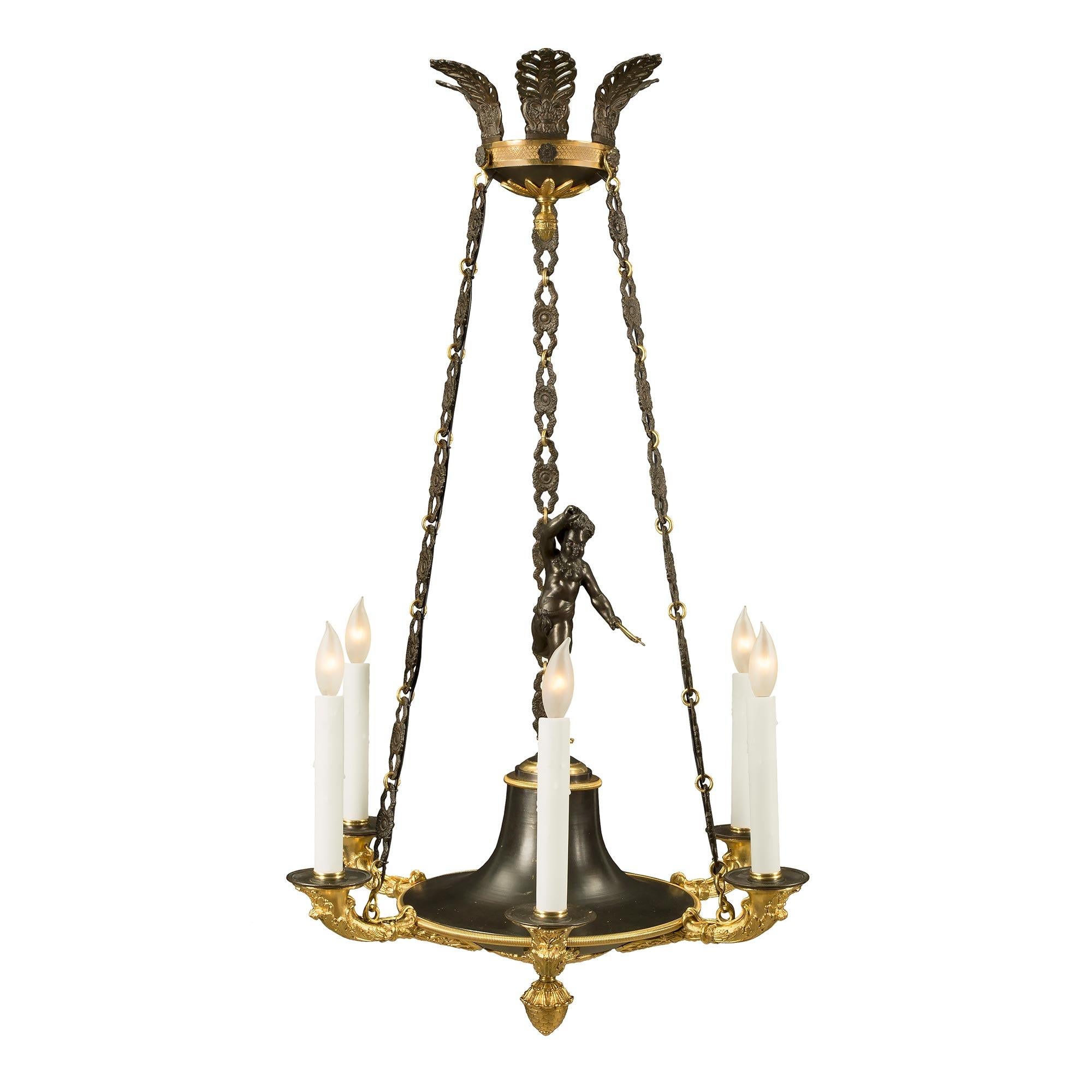 An elegant and most charming French 19th century Neo-Classical st. patinated bronze and ormolu six light chandelier. The chandelier is centered by a lovely bottom ormolu final below the patinated bronze body decorated with lovely foliate movements.