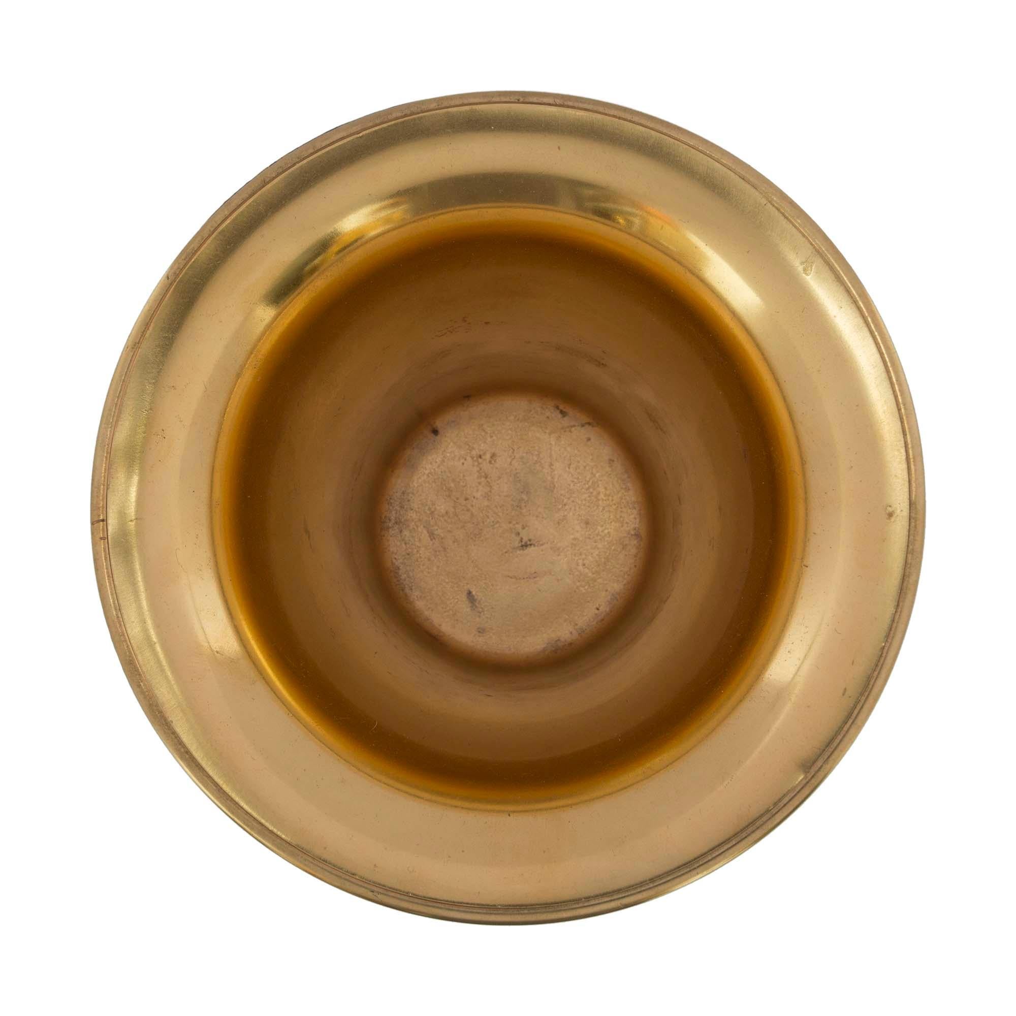 Une sensationnelle urne en bronze patiné et bronze doré de très haute qualité, attribuée à Henry Dasson, de style néo-classique français du 19e siècle. L'urne est surélevée par trois supports en forme de 