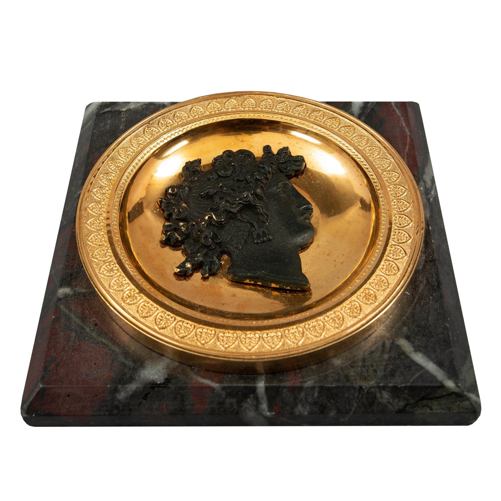 A handsome French 19th century Neo-Classical st. patinated bronze, ormolu and marble paperweight. The base of the paperweight is a square maroon and gray marble with a mottled border. At the center is a striking and richly chased patinated bronze