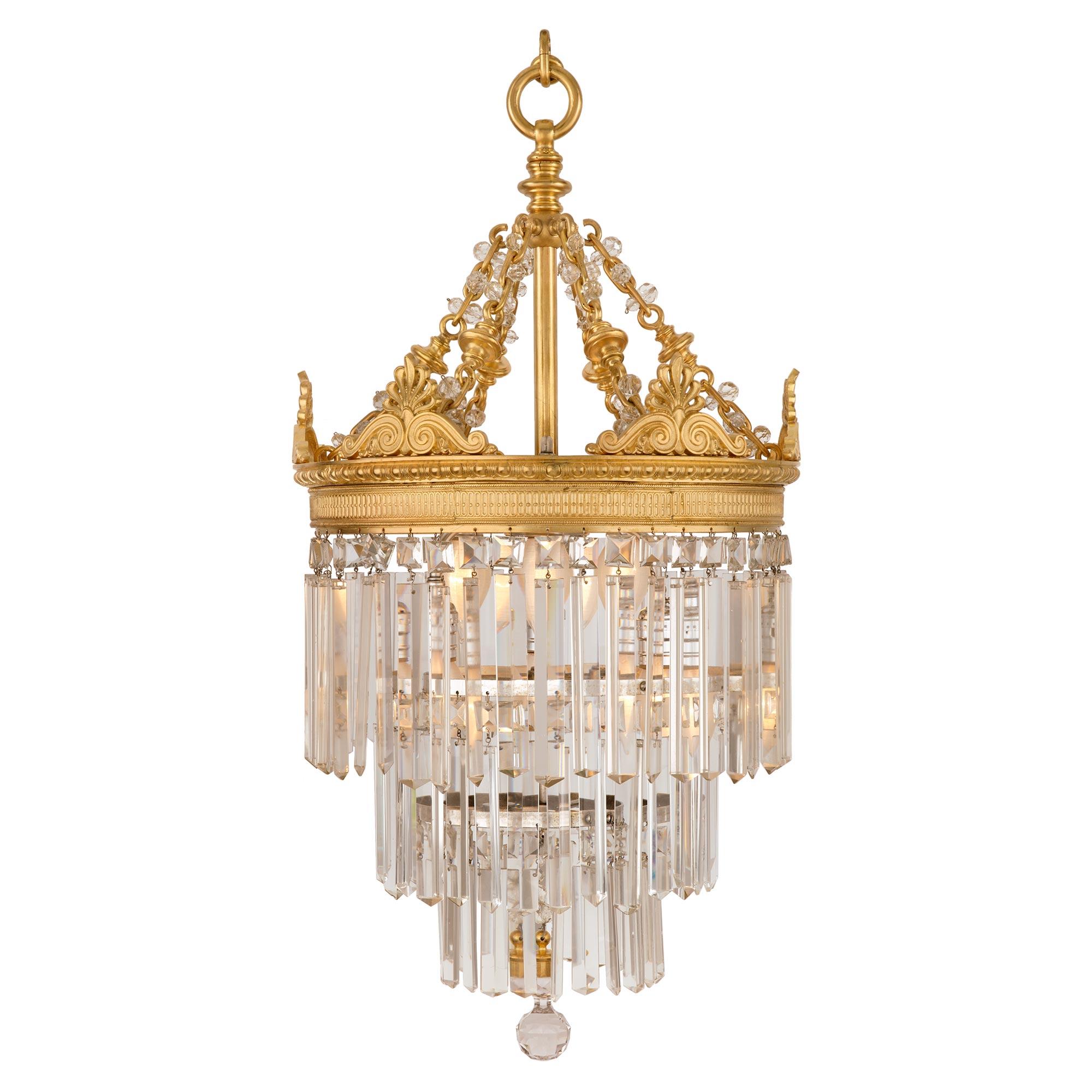 A fabulous French 19th century neoclassical St. ormolu and Baccarat crystal chandelier. The chandelier displays an elegant cut crystal ball centered by three tiers of most decorative prism shaped cut crystal pendants tied to silvered bronze