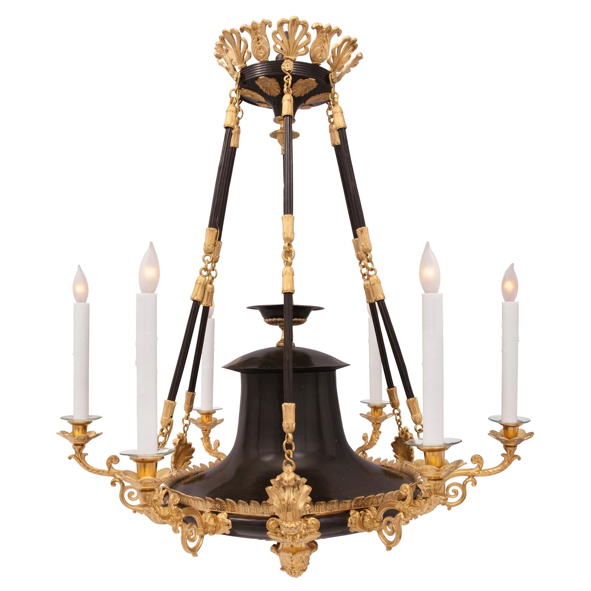 A handsome French 19th century neo-classical st. patinated bronze and ormolu six arm chandelier. The chandelier is centered by a striking inverted foliate acorn bottom finial amidst decorative acanthus leaves. The elegant patinated bronze body