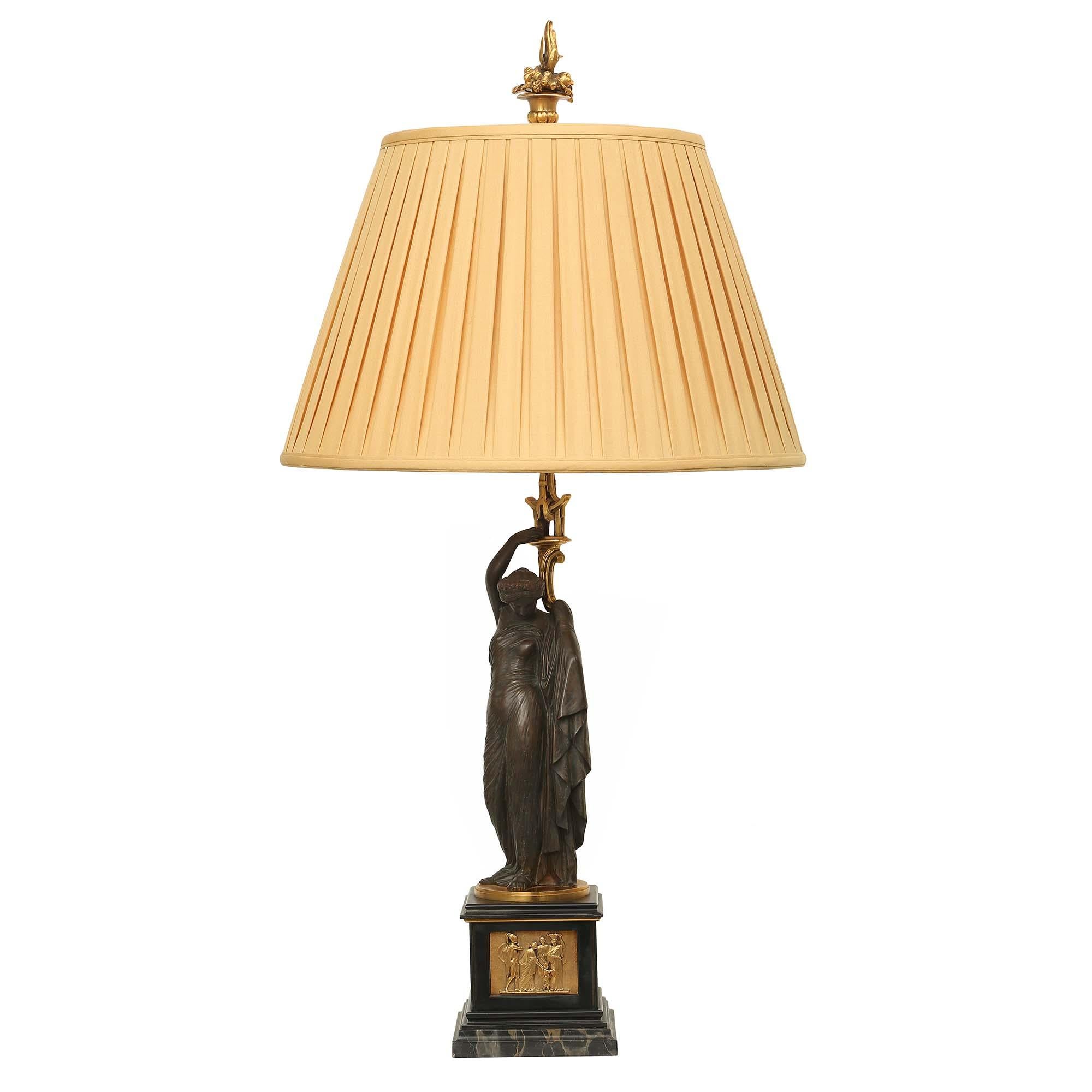 A stunning pair of French 19th century neo-classical st. patinated bronze and ormolu lamps, signed J. Pradier. Each lamp is raised on a square moulded marble base with a finely chased ormolu plaque depicting scenes of Roman soldiers. Above are