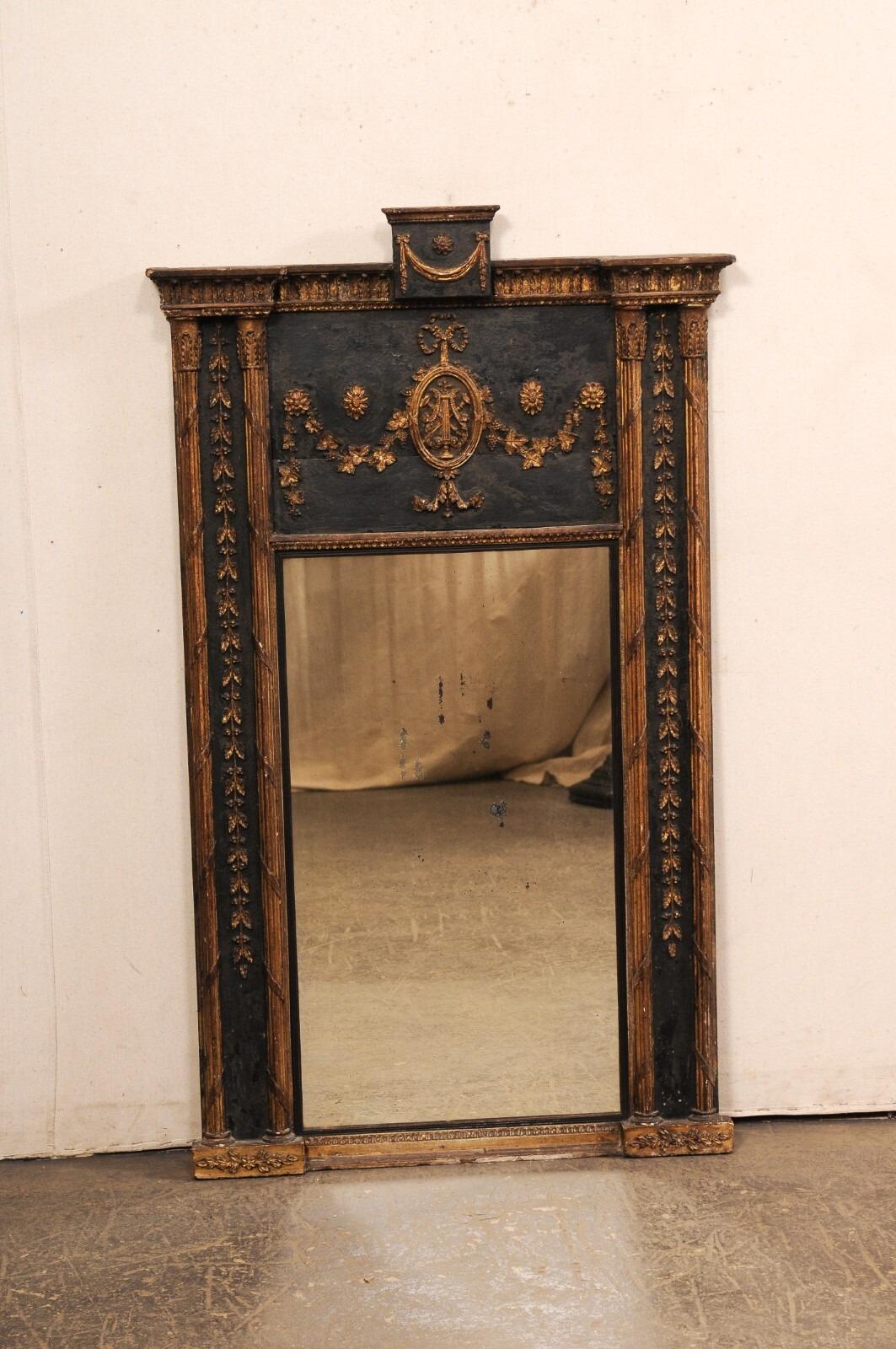 Specchio trumeau neoclassico francese in legno dipinto, con dettagli di rifinitura ben intagliati, risalente al XIX secolo. Questo specchio antico proveniente dalla Francia è di forma rettangolare e presenta un'asta superiore intagliata a foglie