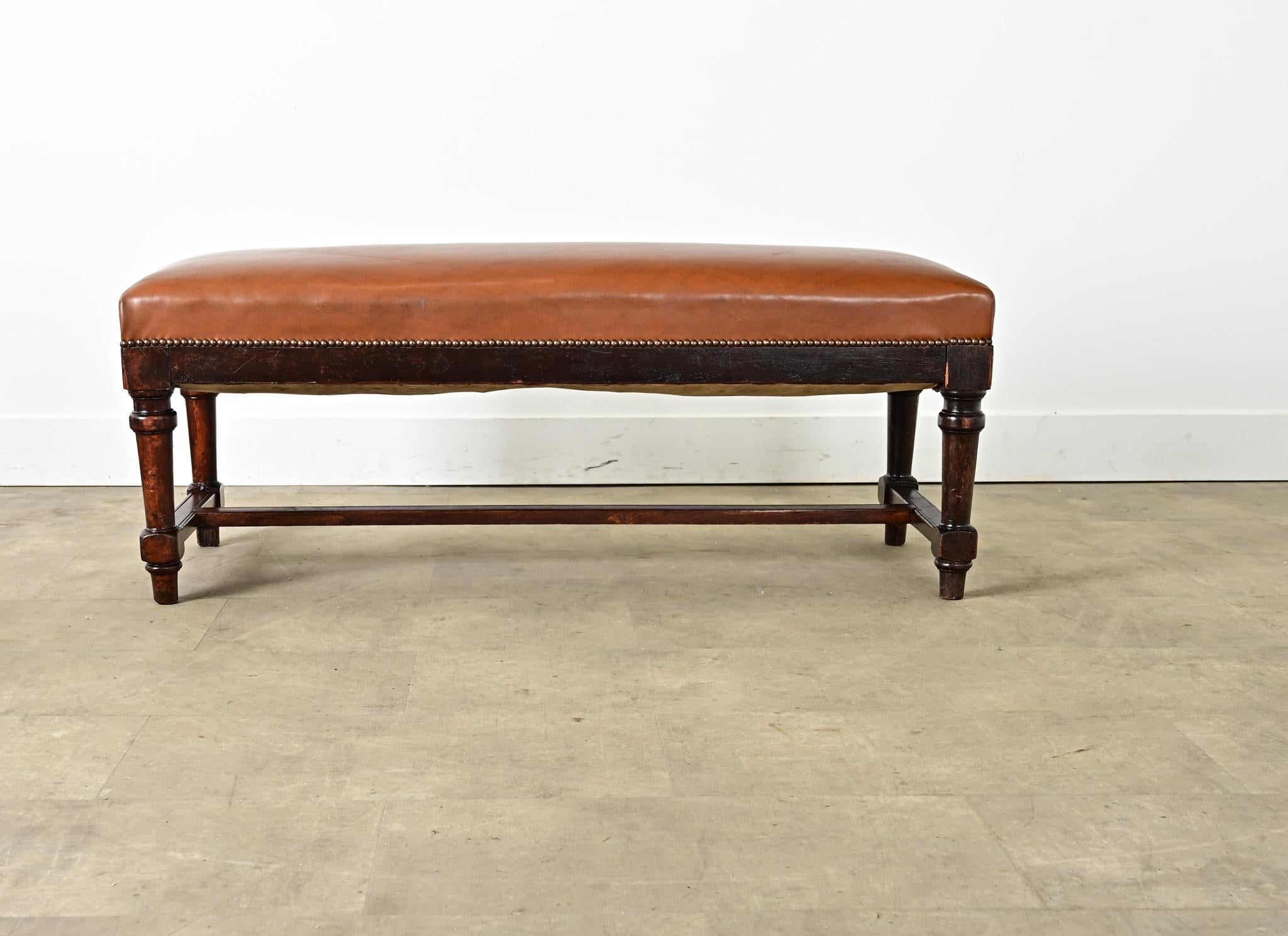 A 19th century French oak bench with robust, rectangular proportions to suit a living room, library, hallway, or bedroom, upholstered more recently with a faux leather seat for ease of maintenance. The caramel-toned top is given subtle definition