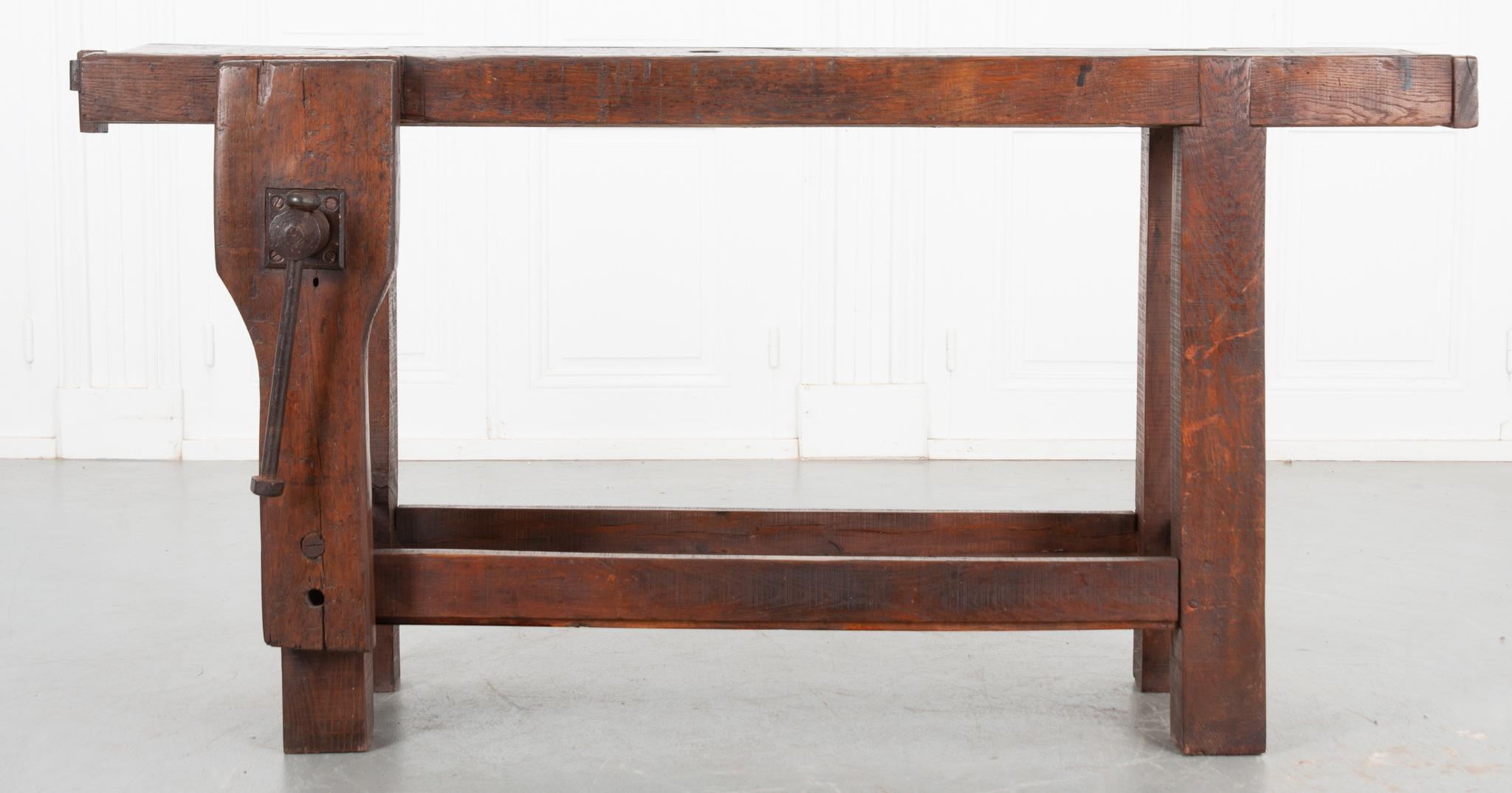 This 19th century French workbench would be perfect behind a sofa or as a functioning workbench. Made of solid oak, the top is 3” thick and has one dowel hole. A fantastic patina enhances the antique feel of the dark wood. Visible signs of wear are