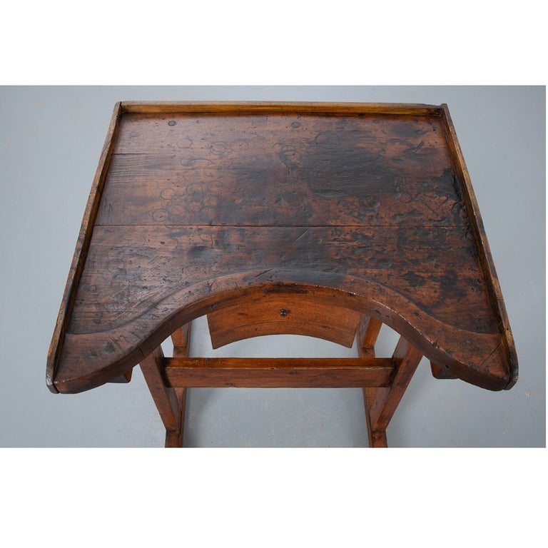 This specialized oak desk was made in France. Used by artists, the desk’s lifted surface brings the table towards the artist, minimizing reach, and saving their aching backs. The work surface has a three quarter wood gallery and raised surface
