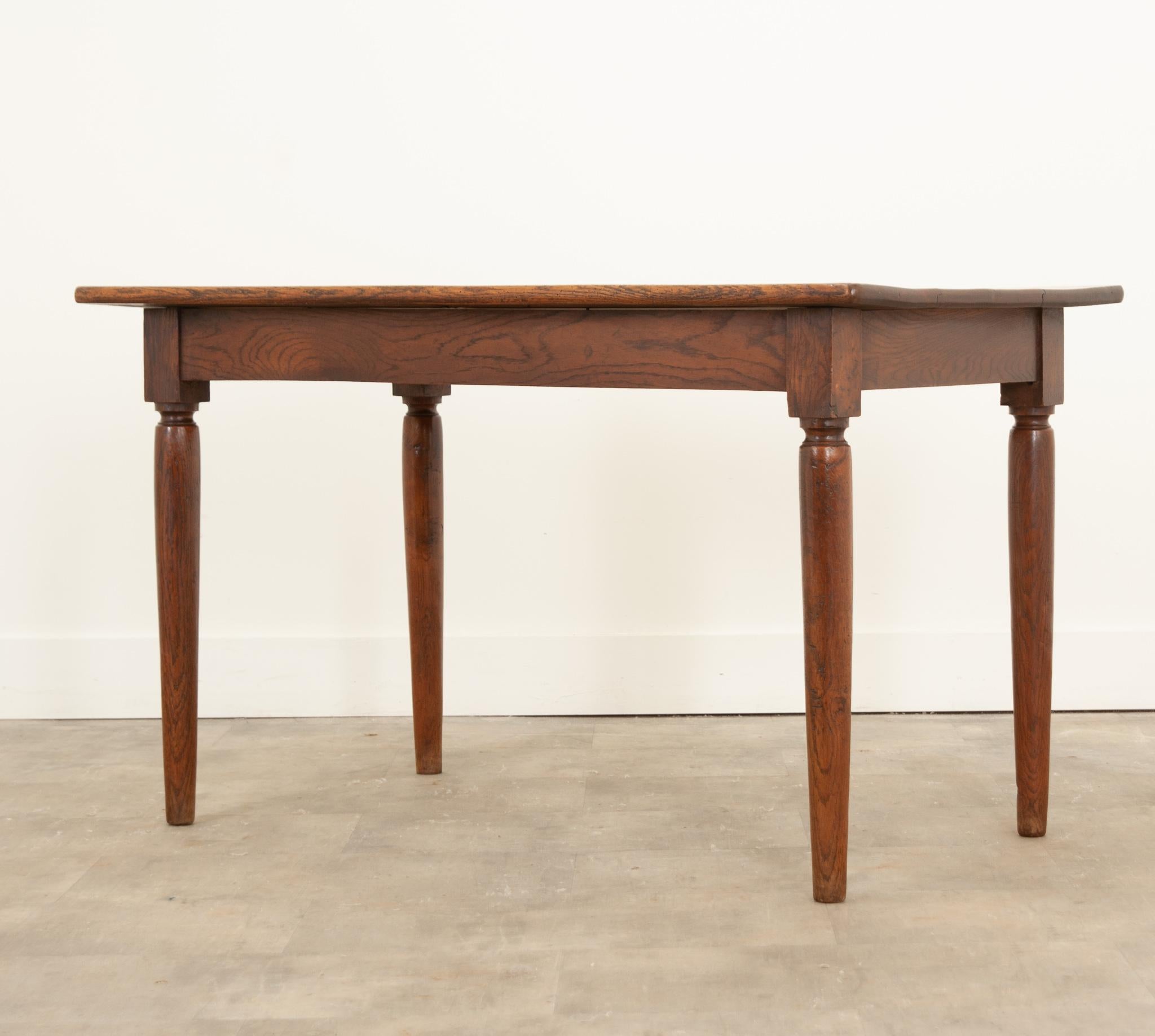 A simply elegant French solid oak bistro table hand-crafted in 19th century France. This unassuming table has subtle stylings that make it anything but simple. Beautiful expressions can be found in the grain of the oak, which has a spectacular tone