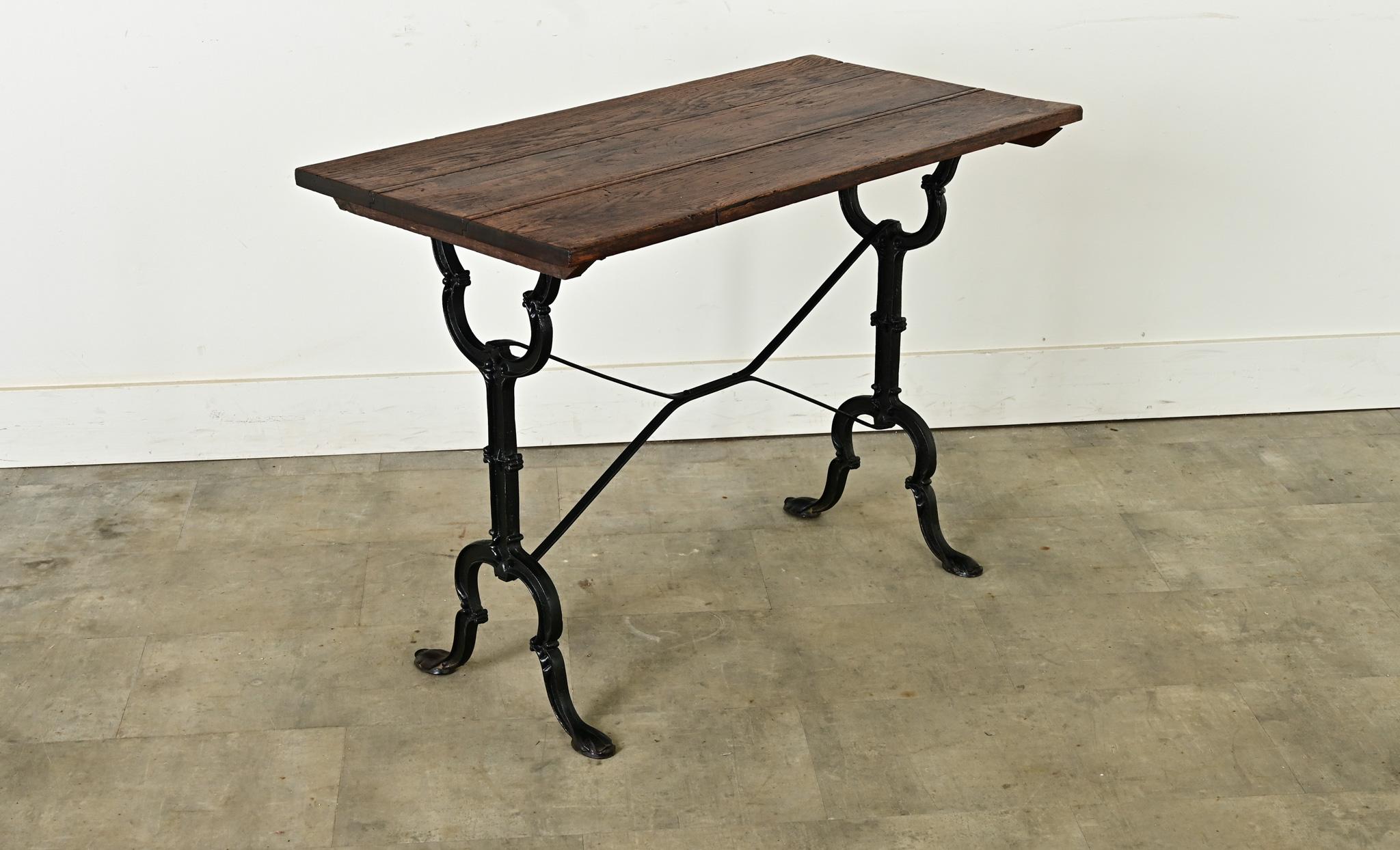 Excepcional mesa bistro francesa del siglo XIX, con personalidad y detalles estilizados en la base de hierro fundido. Los tablones de roble oscuro tienen una superficie bien patinada -consistente con la edad y el tipo de uso- que constituye un