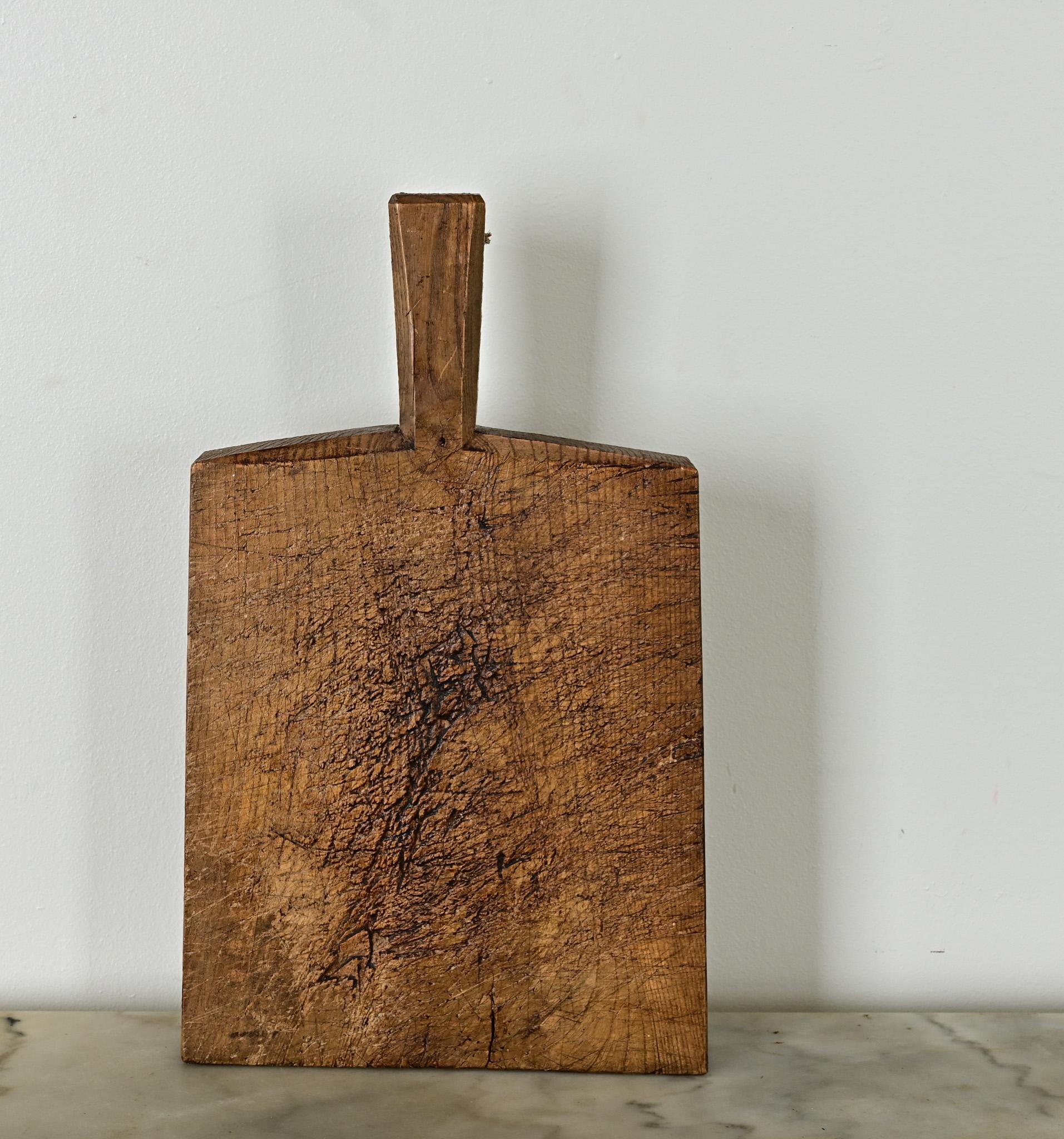 Exceptional oak chopping block from France, 19th century. The solid wood plank is expertly carved with good symmetry. A comfortable bevel on the handle is a sophisticated touch, giving this design a unique look and modern appeal to continue using.