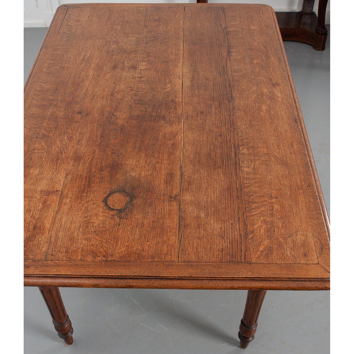 A spectacular oak farmhouse table from France, c. 1890. The table’s top consists of five boards that are framed around the edges. An exaggerated overhang is unusual for dining tables and adds a unique quality to this piece. The whole is lifted by
